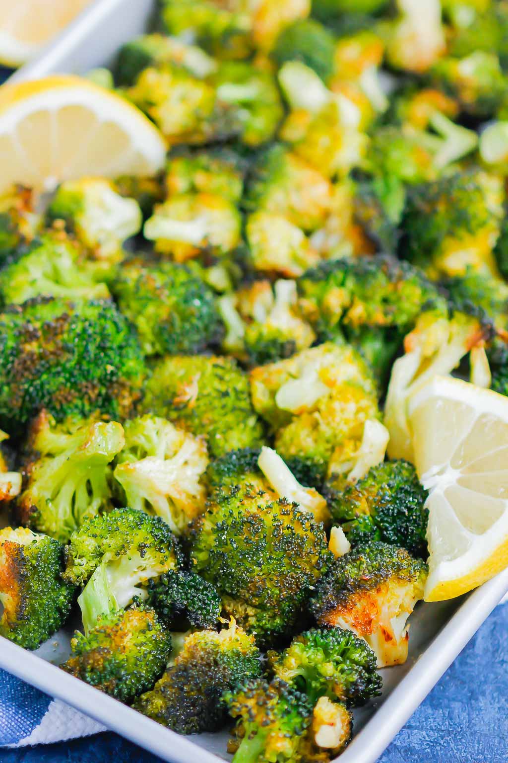 roasted lemon garlic broccoli on a baking sheet with lemon wedges 