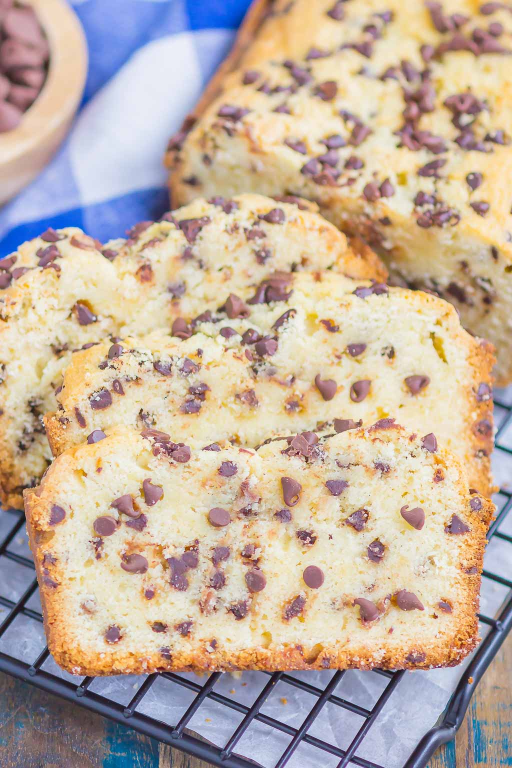 Three slices of chocolate chip pound cake on a wire cool rack. The rest of the cake is in the background. 