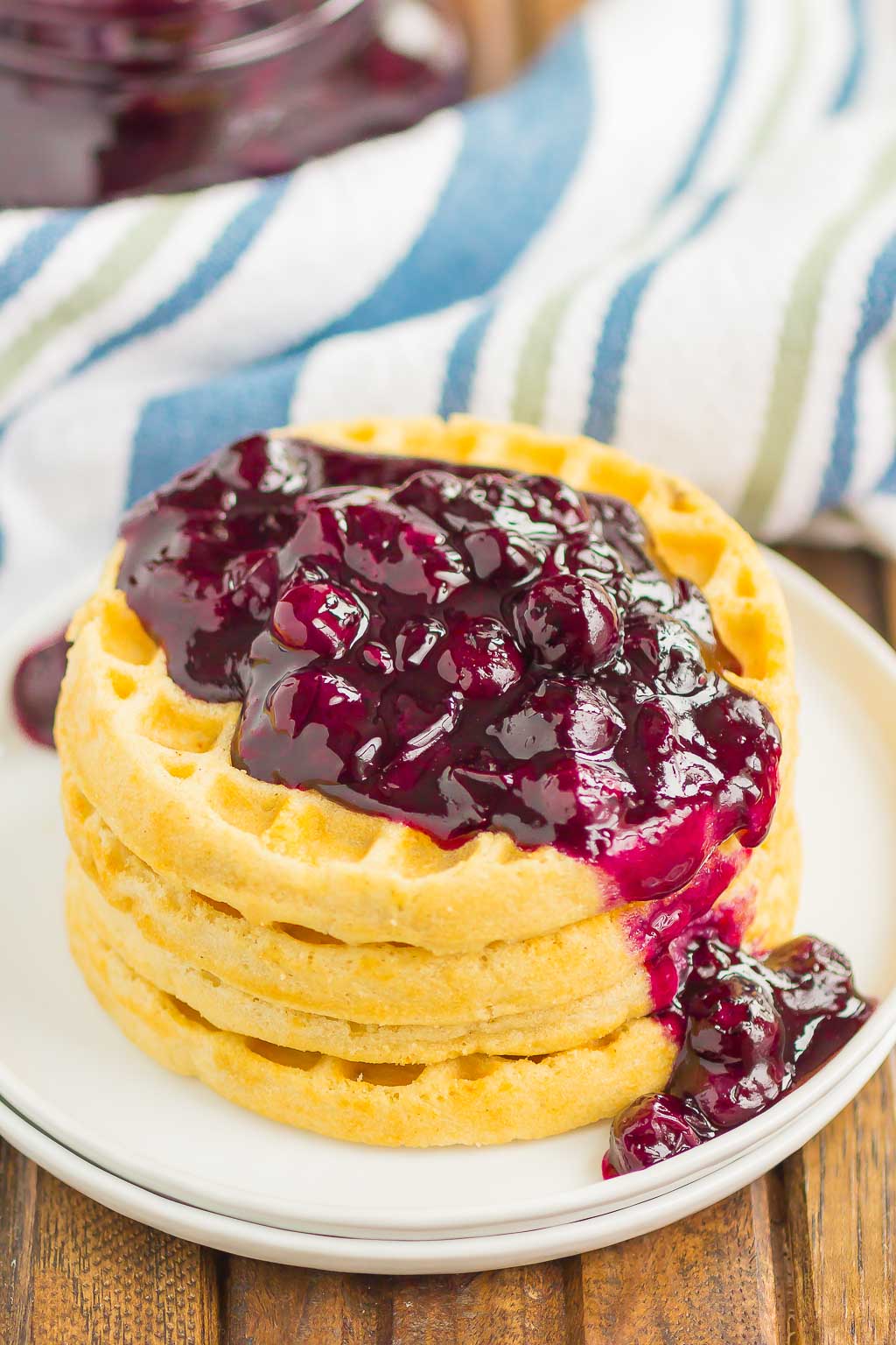 Blueberry sauce spooned over a stack of waffles. 