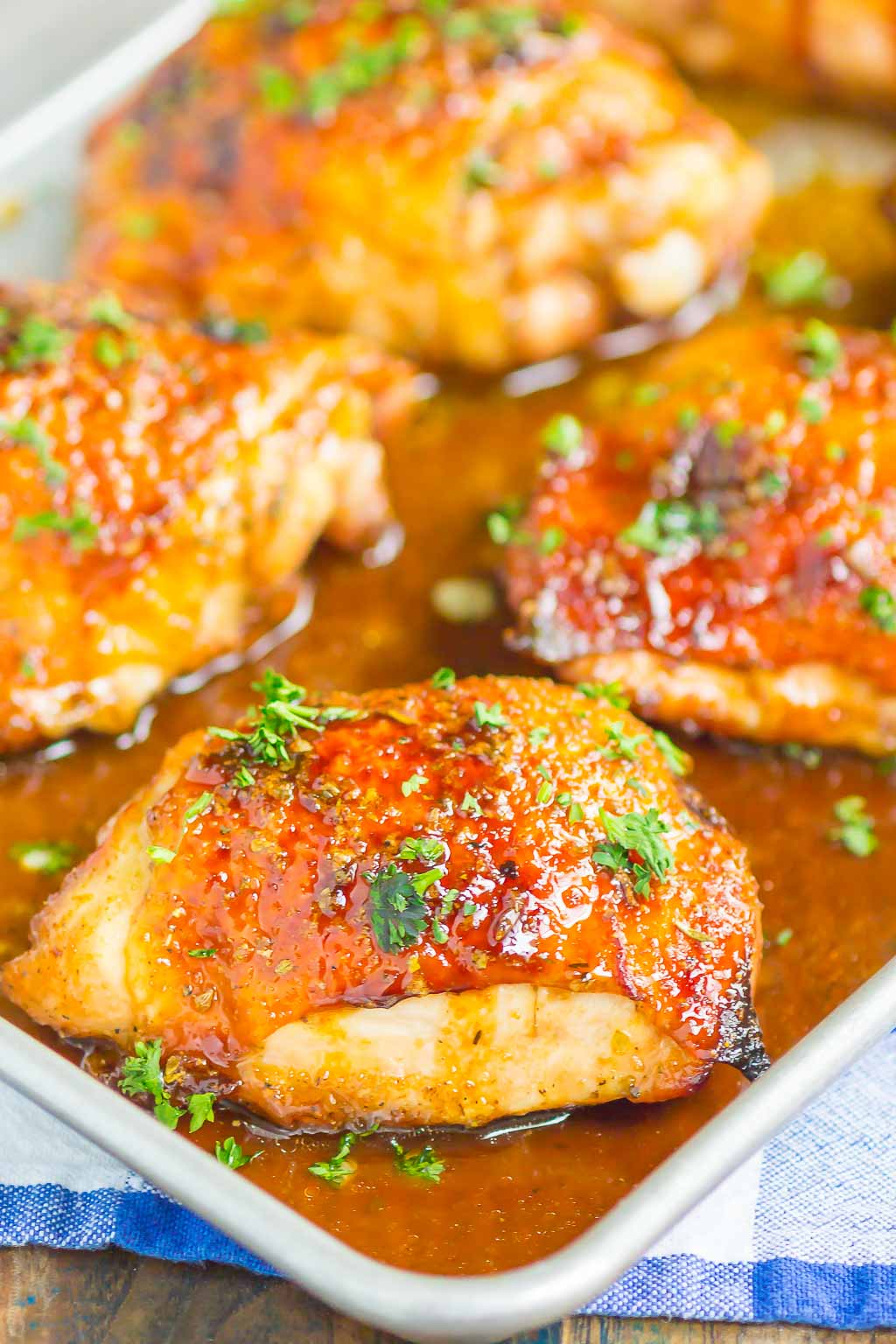 four honey balsamic chicken thighs on a baking tray