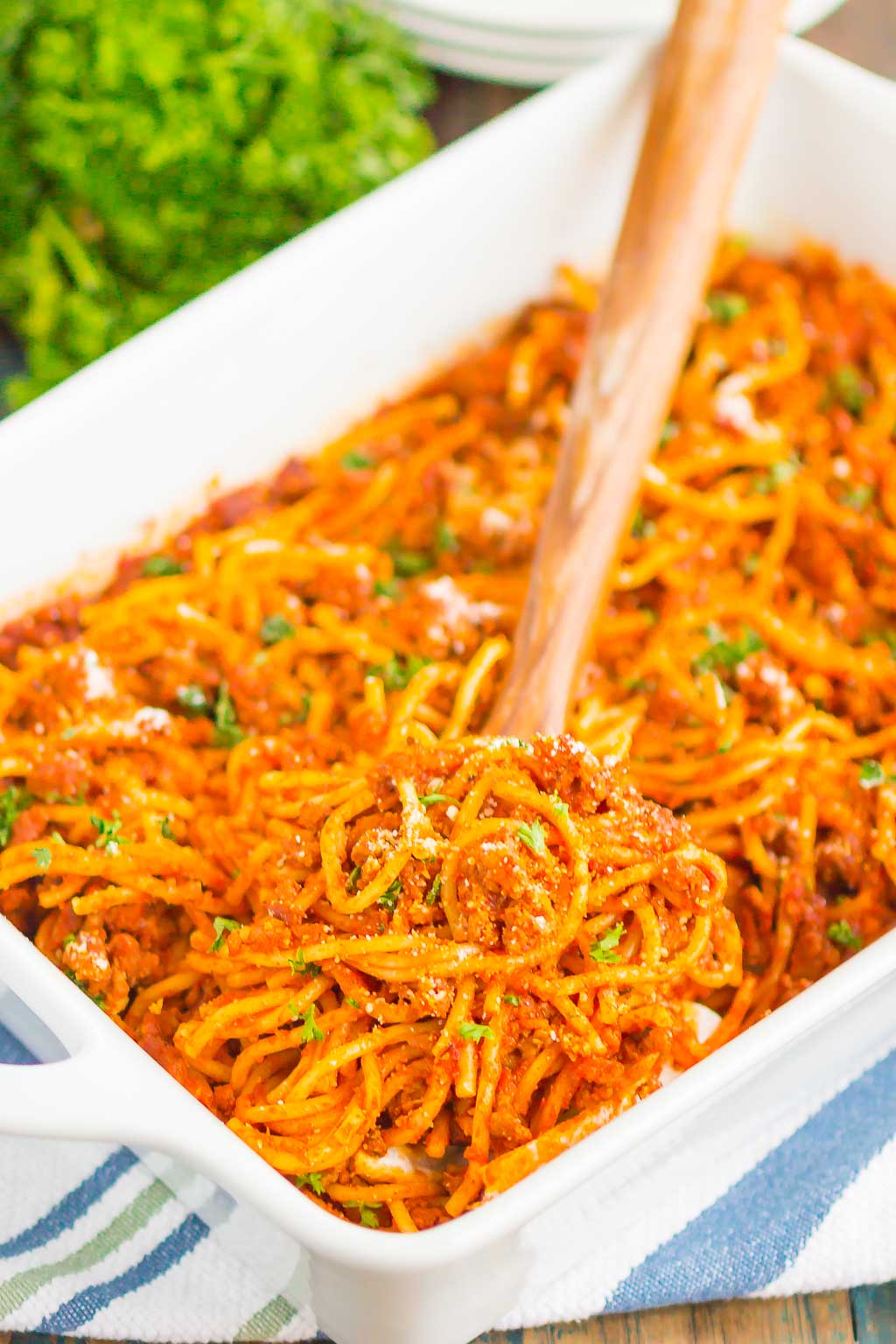 a portion of easy baked spaghetti being lifted from a casserole dish