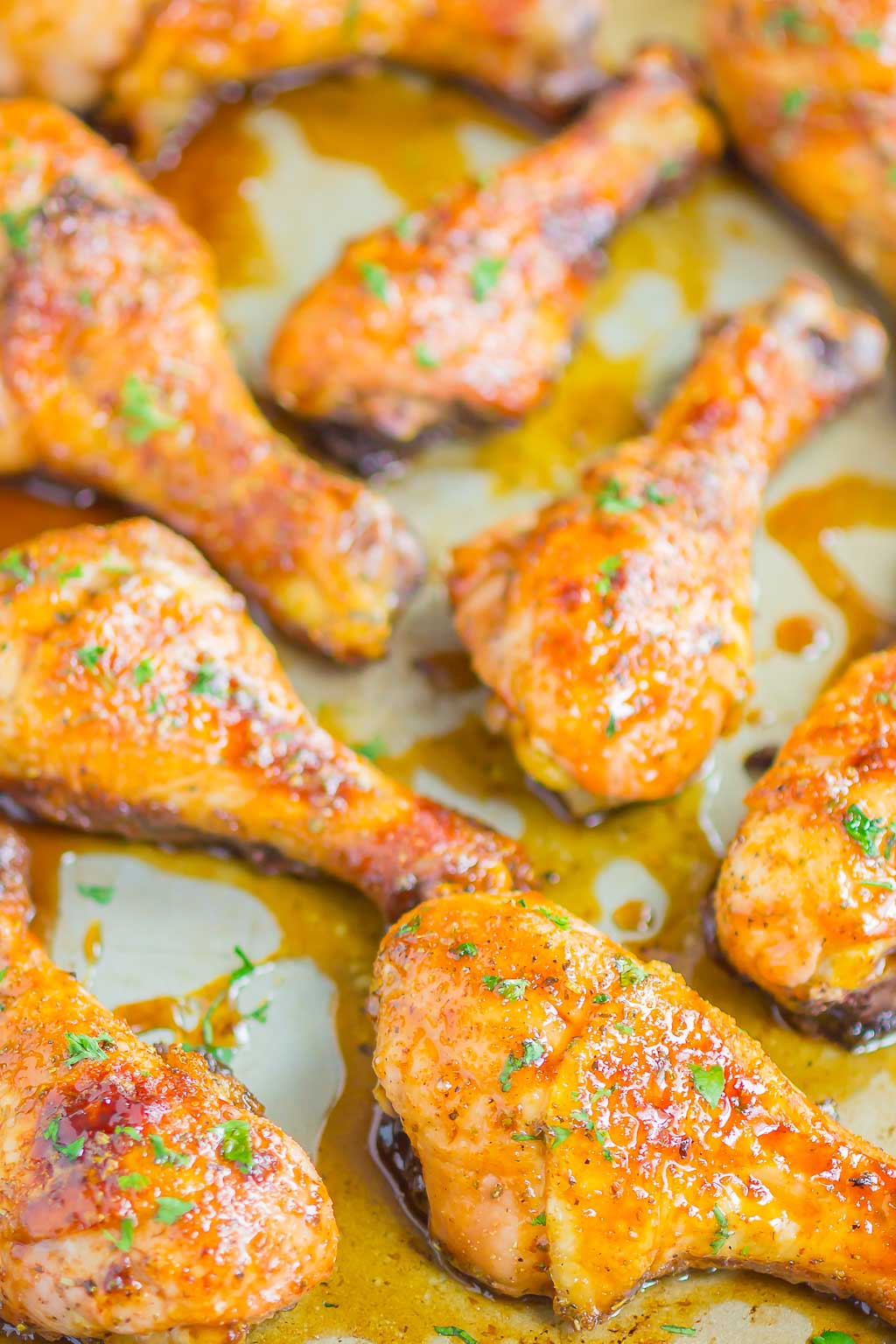 Baked chicken drumsticks topped with honey-soy glaze on a baking sheet. 