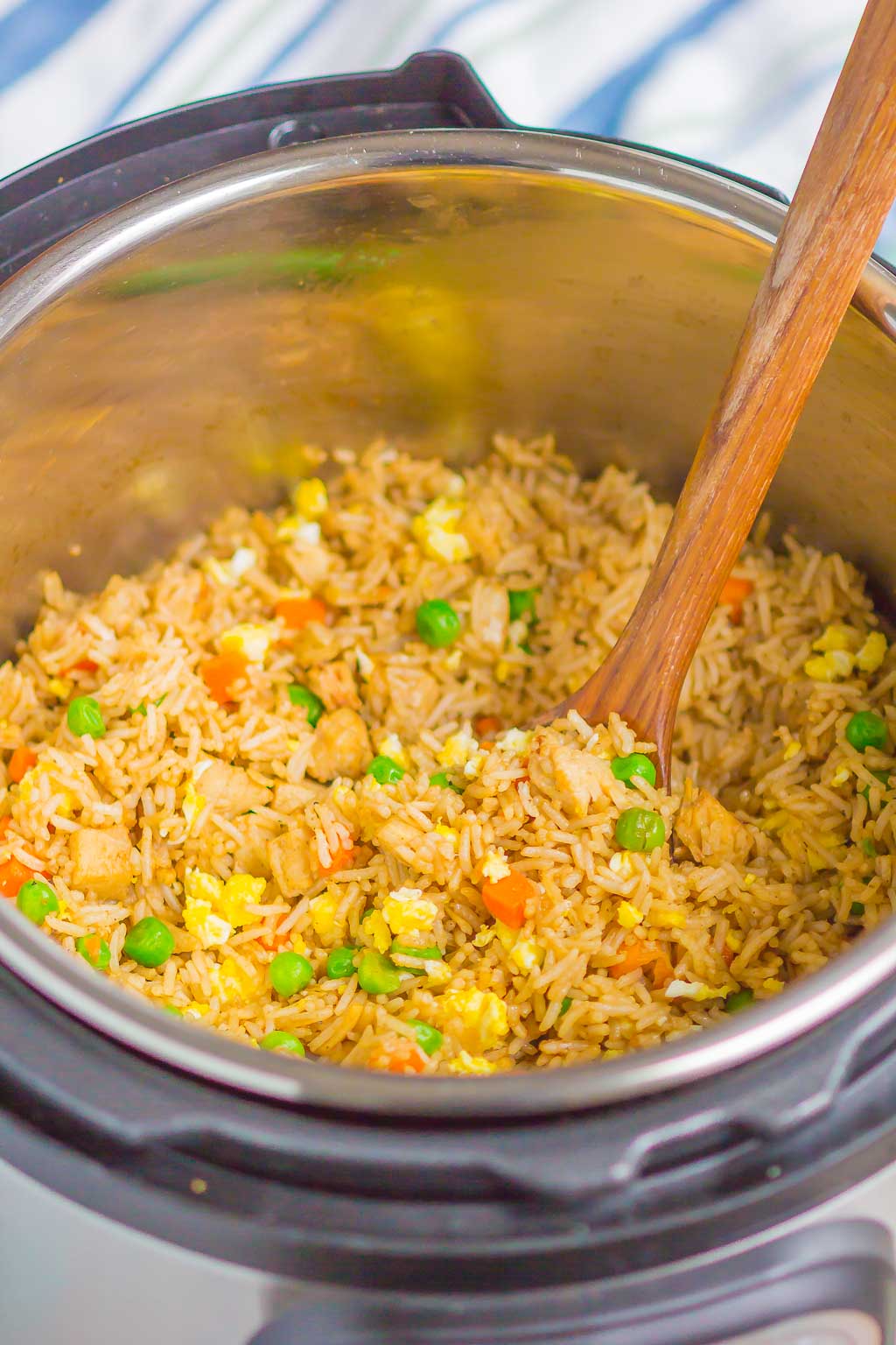 view of pressure cooker fried rice with a wood spoon sticking out 