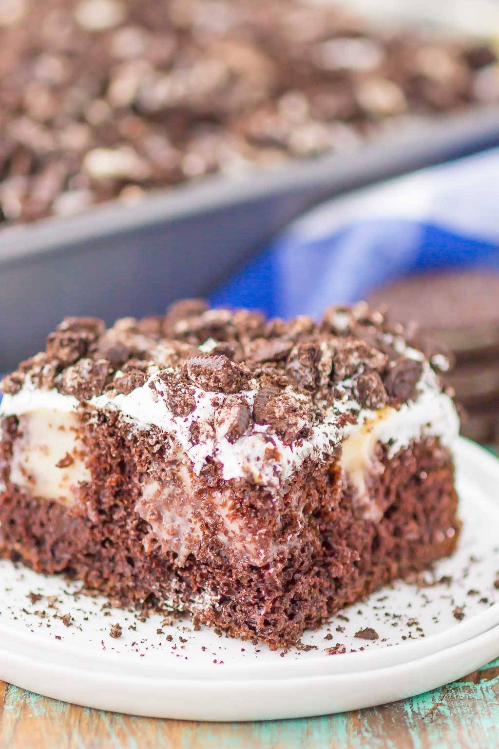 A slice of Oreo pudding cake on a speckled dessert plate. 