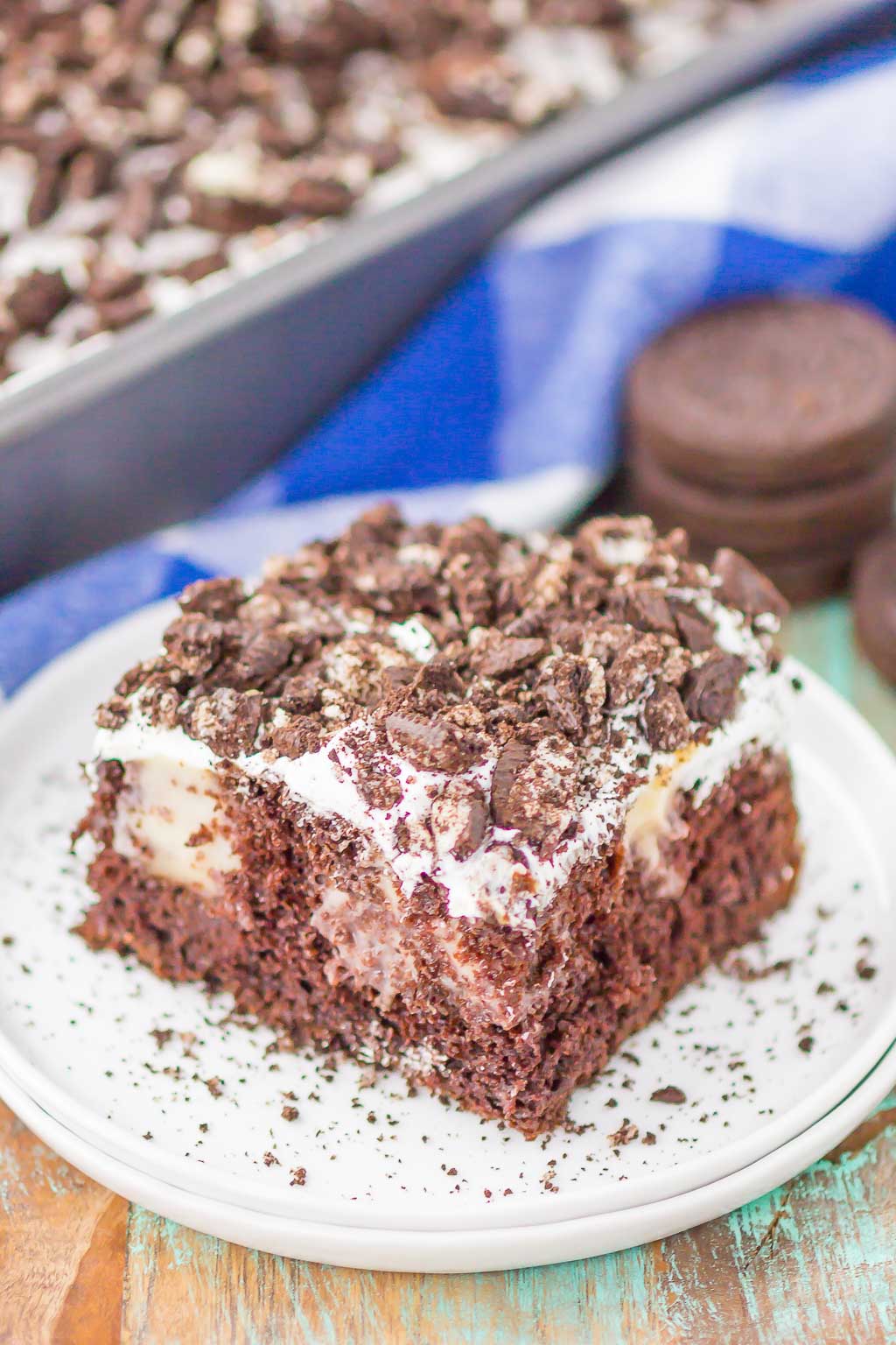 A slice of Oreo poke cake on a speckled dessert plate. 