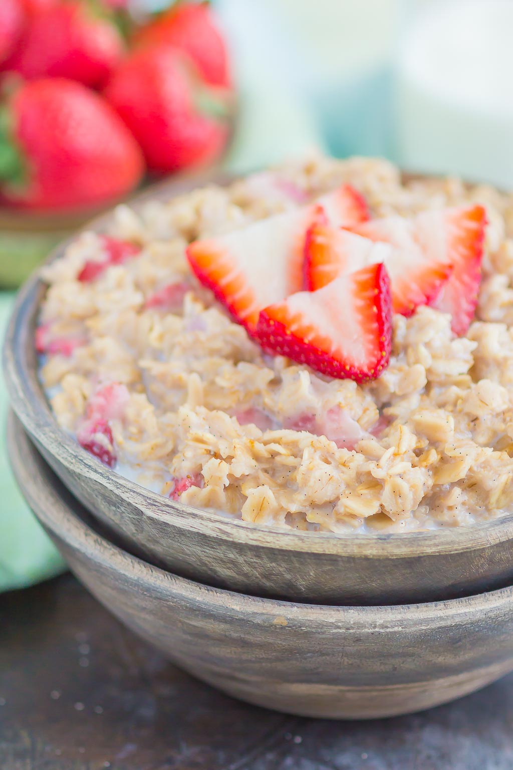 A bowl of strawberry oatmeal, viewed from the side. 