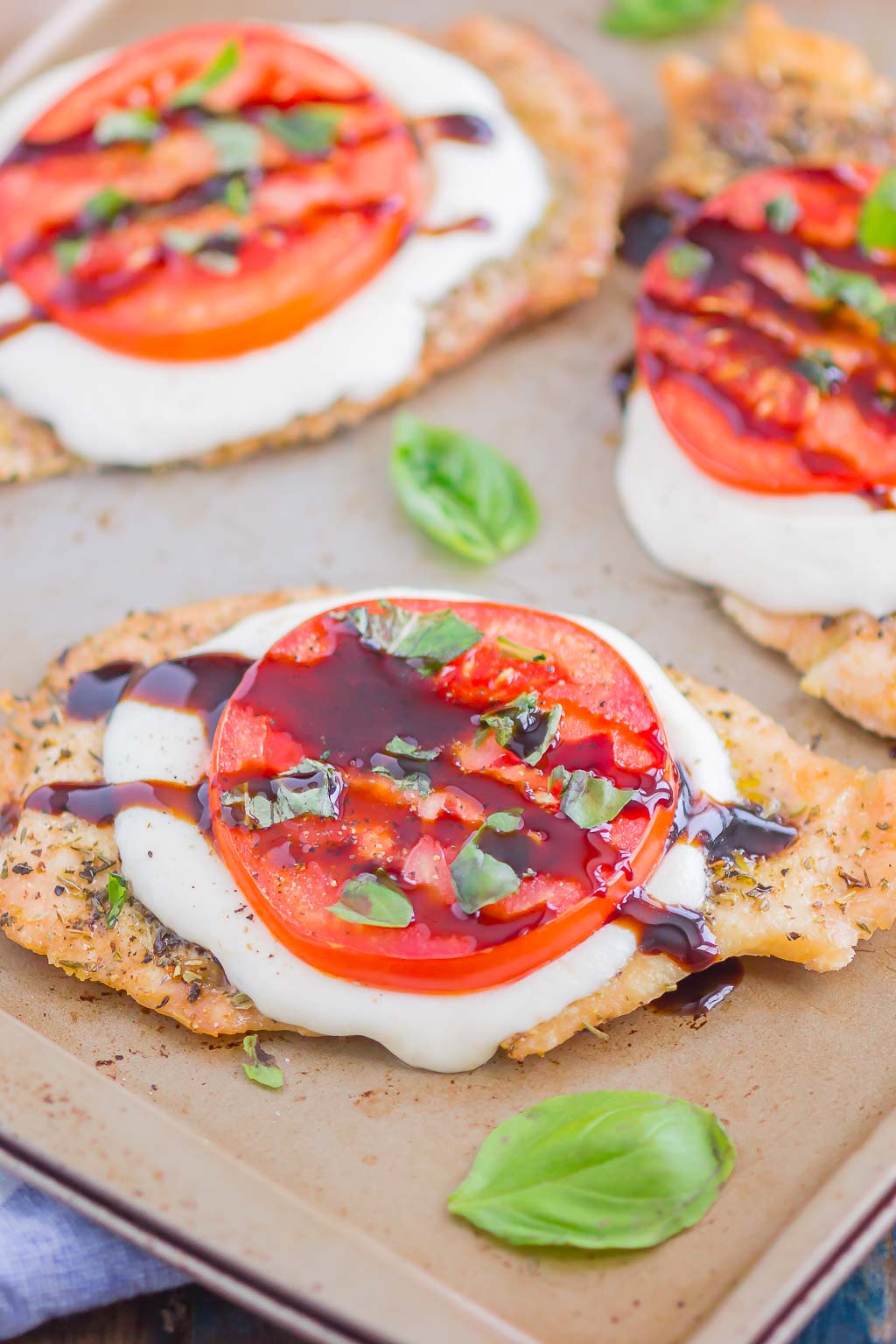 Balsamic caprese chicken breasts on a baking sheet 