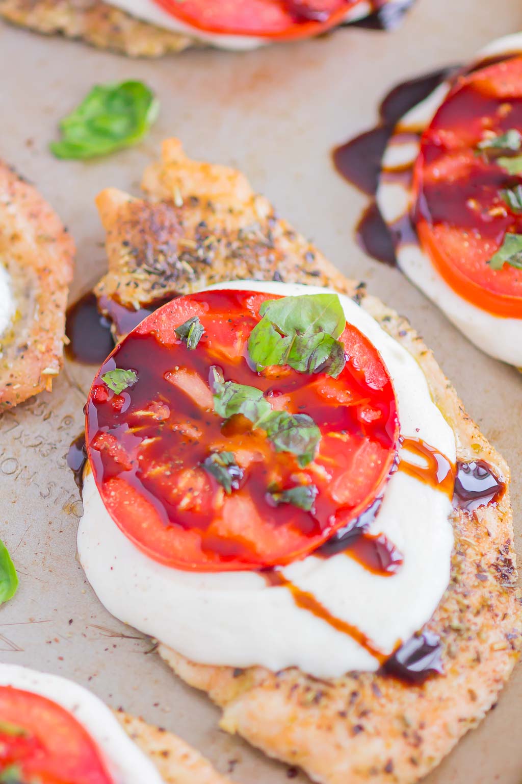 Close up of a balsamic caprese chicken breast on a baking sheet 