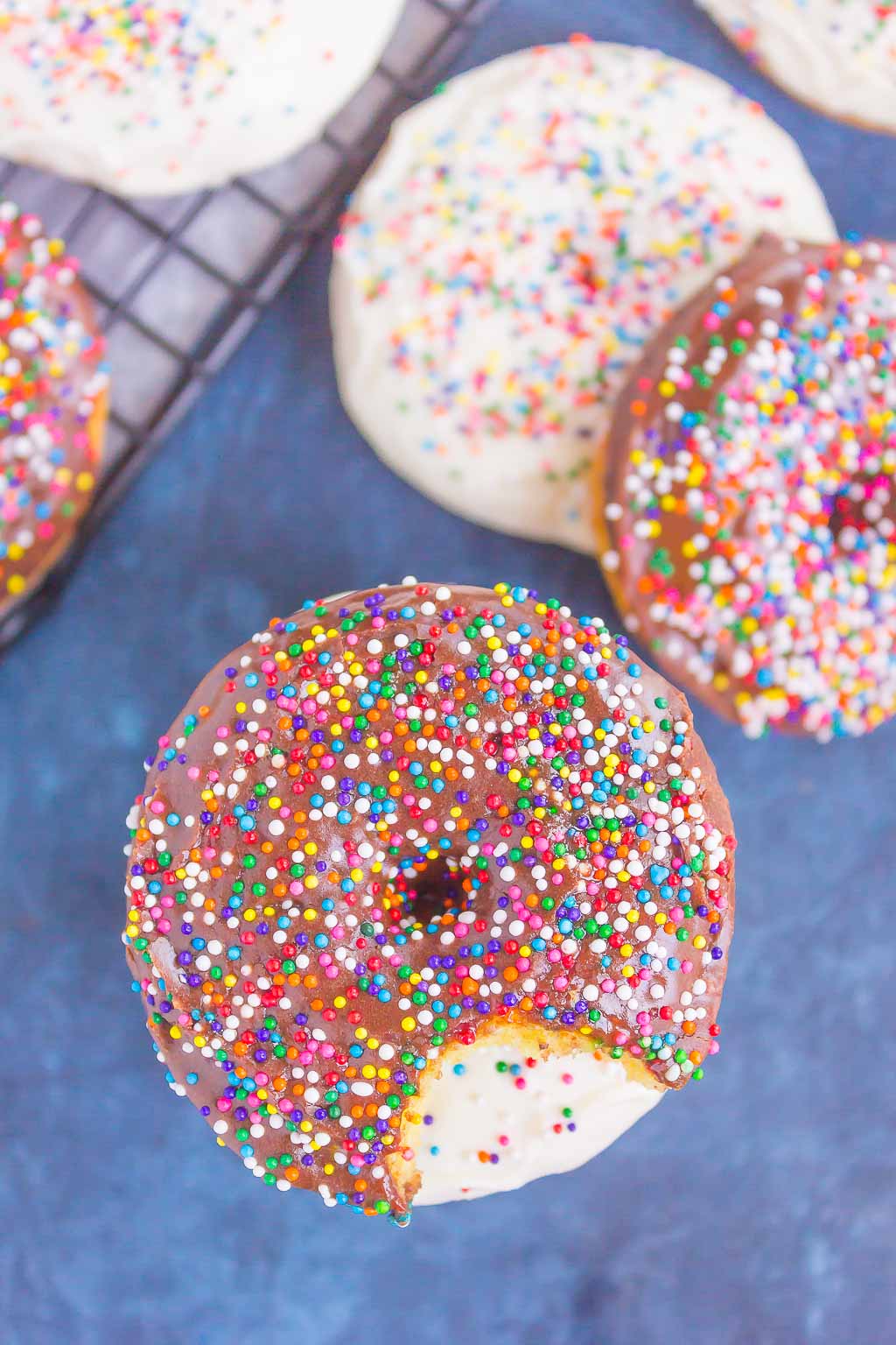 Overhead view of donuts made with cake mix. Some are stacked, some are on a wire rack. 