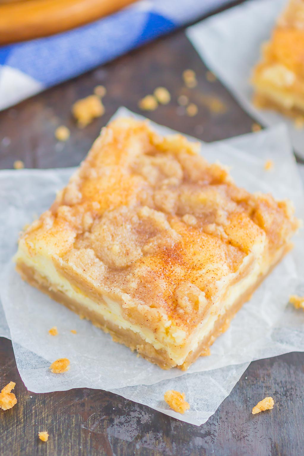 A Snickerdoodle Cheesecake Bar on a square of parchment paper. 