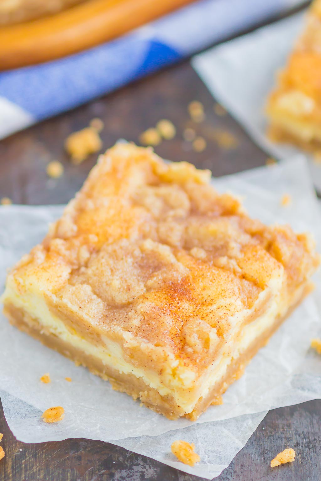 A Snickerdoodle Cheesecake Bar on a square of parchment paper. 