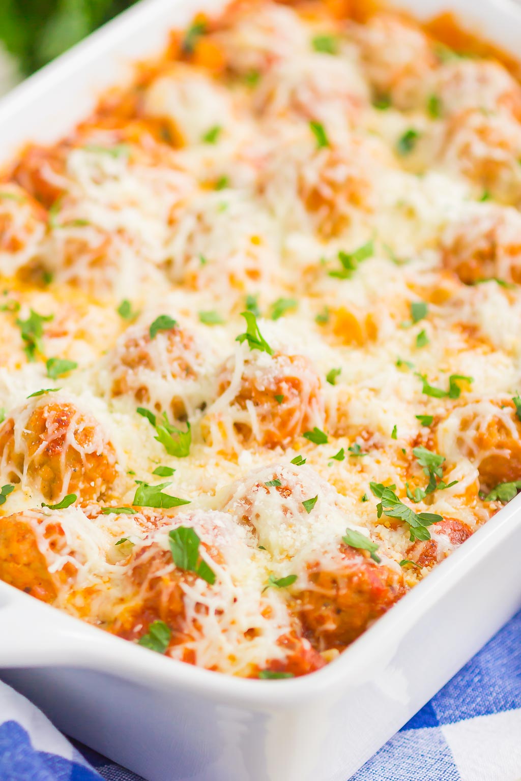 A casserole dish filled with cheesy meatball pasta bake. 