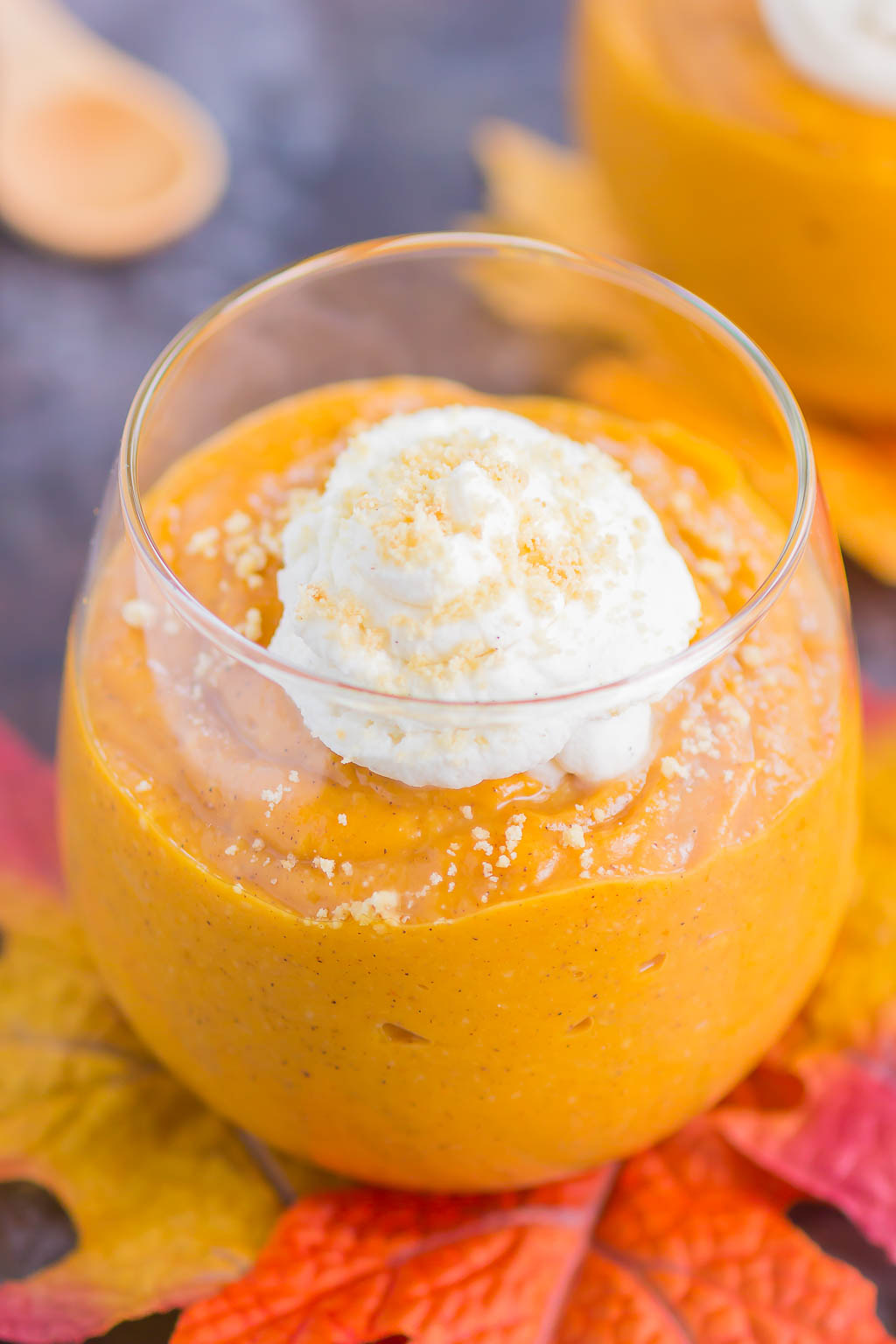 Pumpkin spice pudding in a glass, garnished with whipped cream. 