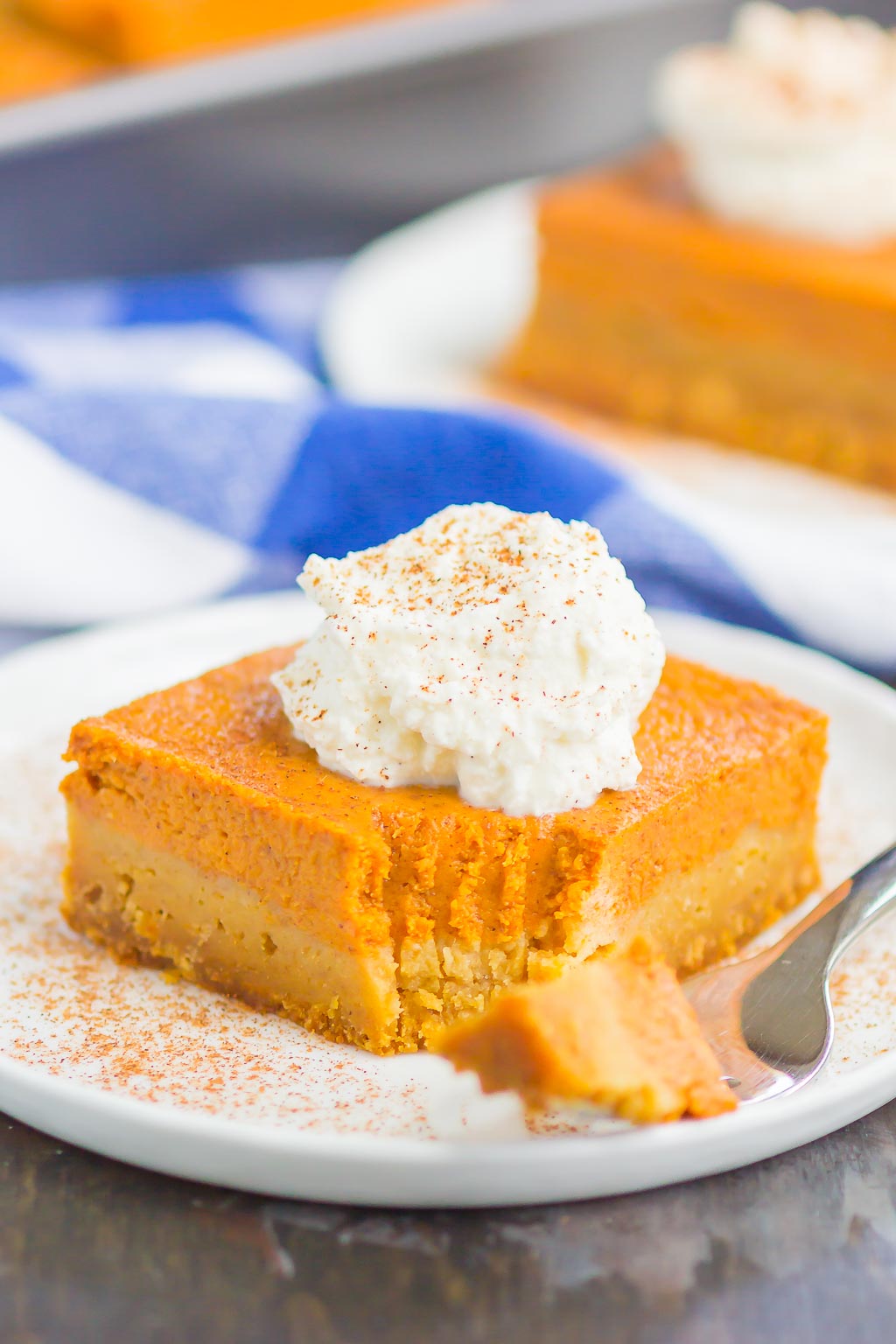 A pumpkin pie bar on a plate. A bite is missing. 