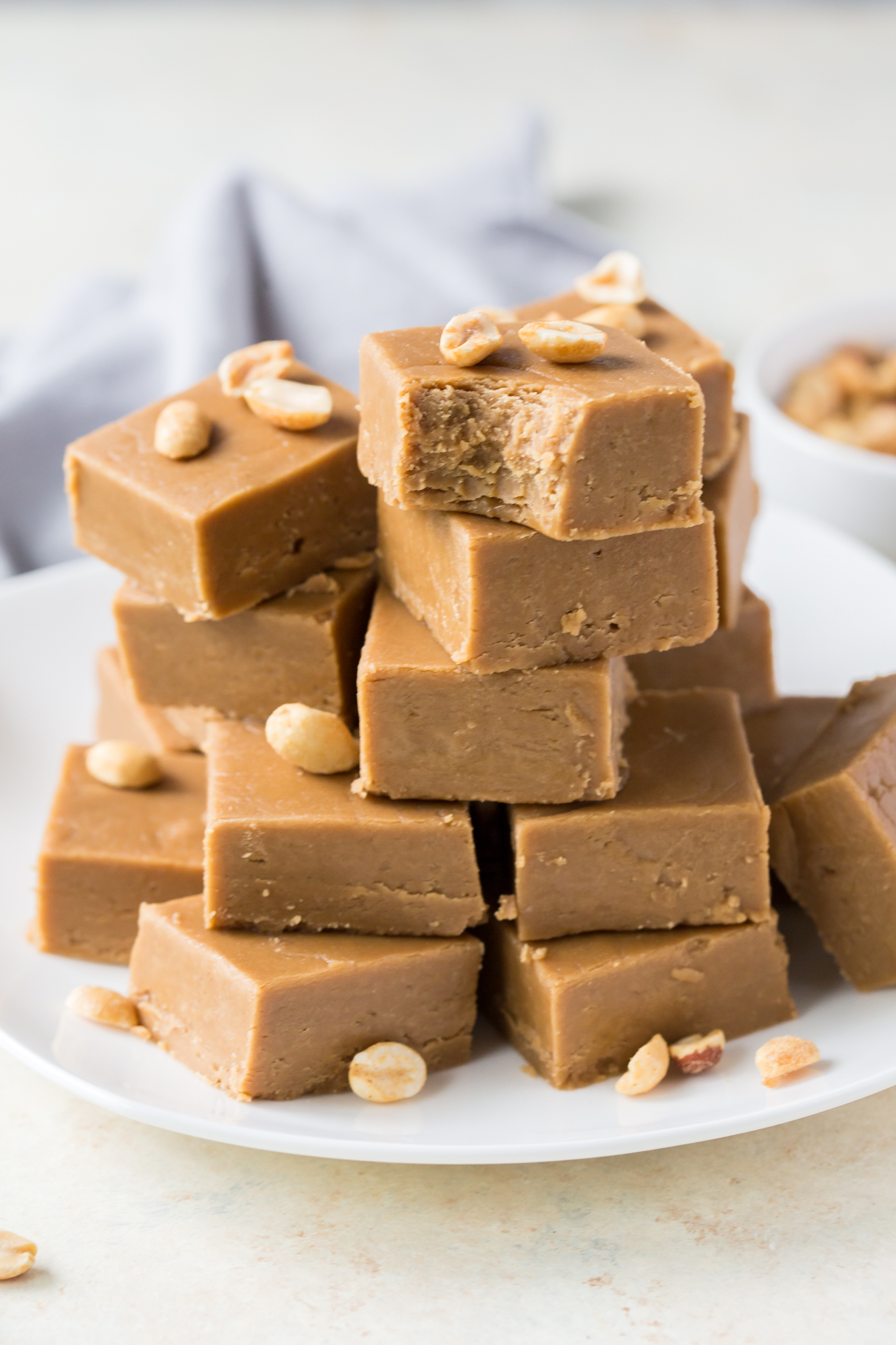 the best Peanut Butter Fudge cut into squares and piled on a white plate 