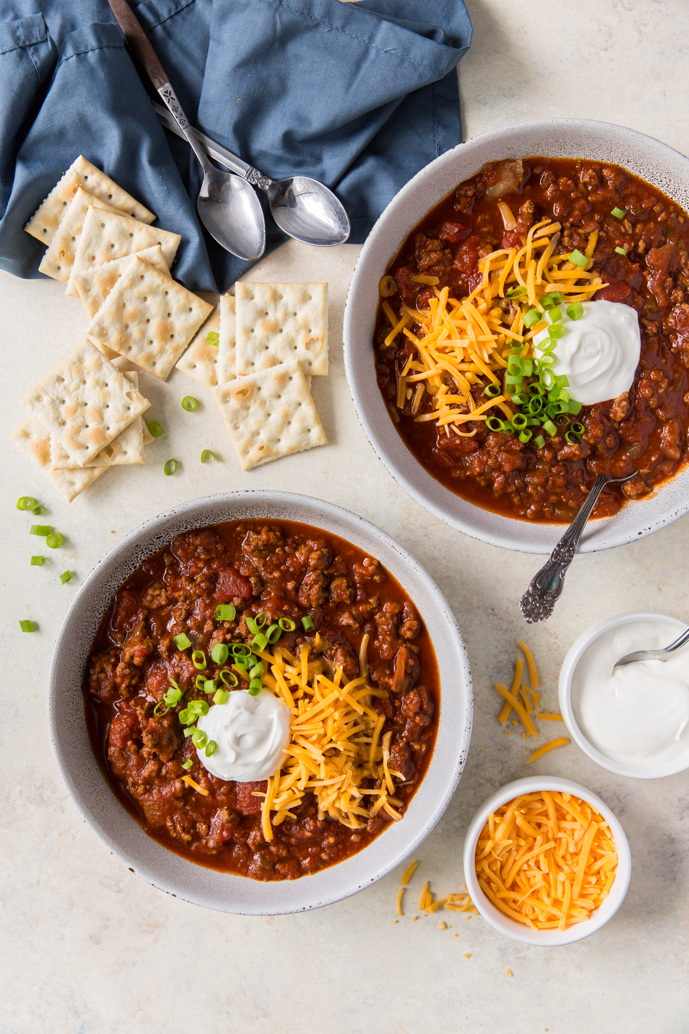 An overhead view of two bowl of beanless chili topped with garnishes.