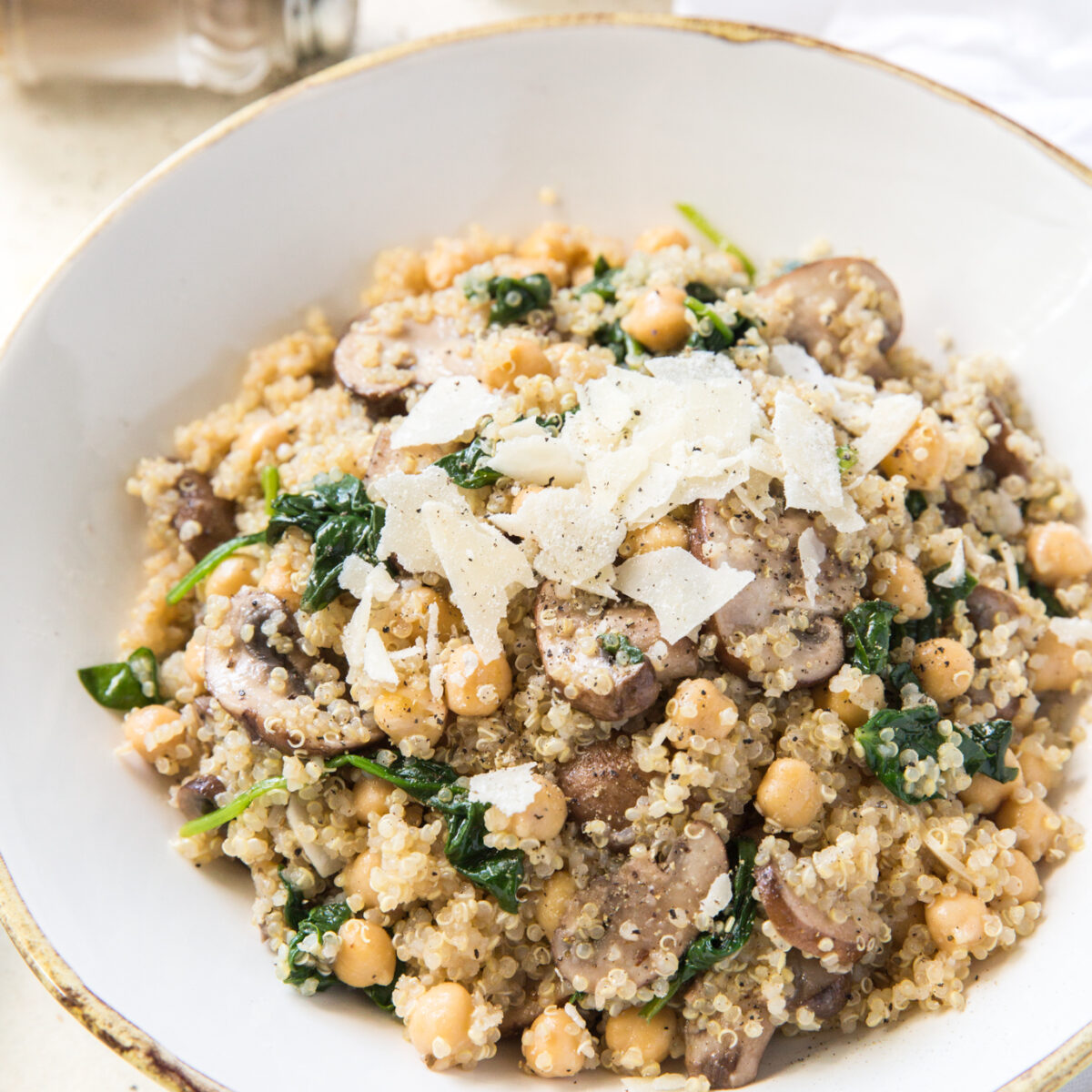 overhead view of a quinoa veggie bowl topped with shaved parmesan