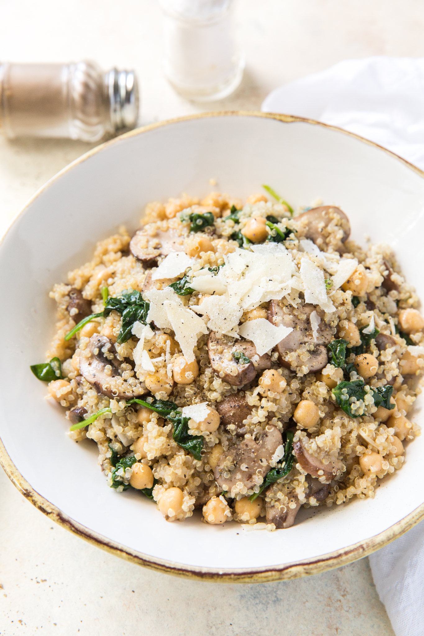 overhead view of a quinoa veggie bowl topped with shaved parmesan 