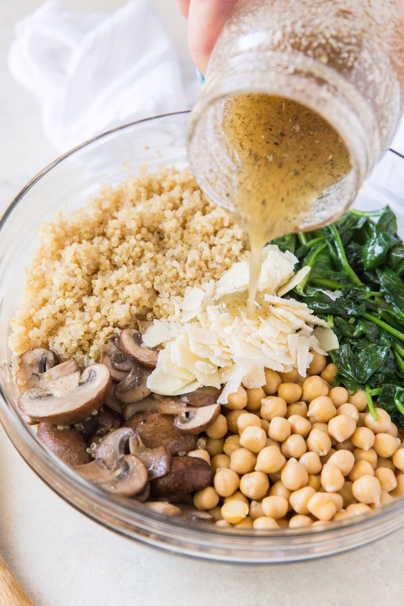 white balsamic dressing being poured over quinoa and veggies 