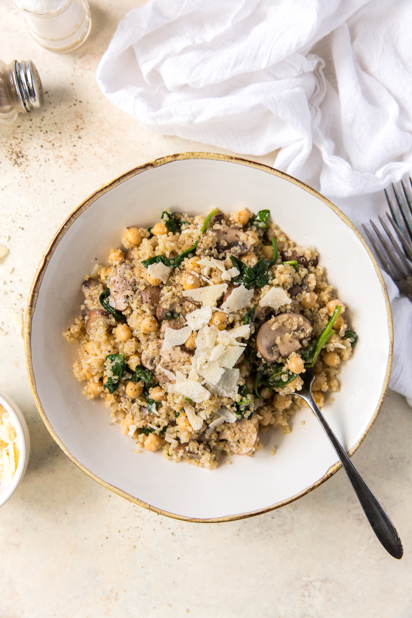 overhead view of a quinoa veggie bowl topped with shaved parmesan 