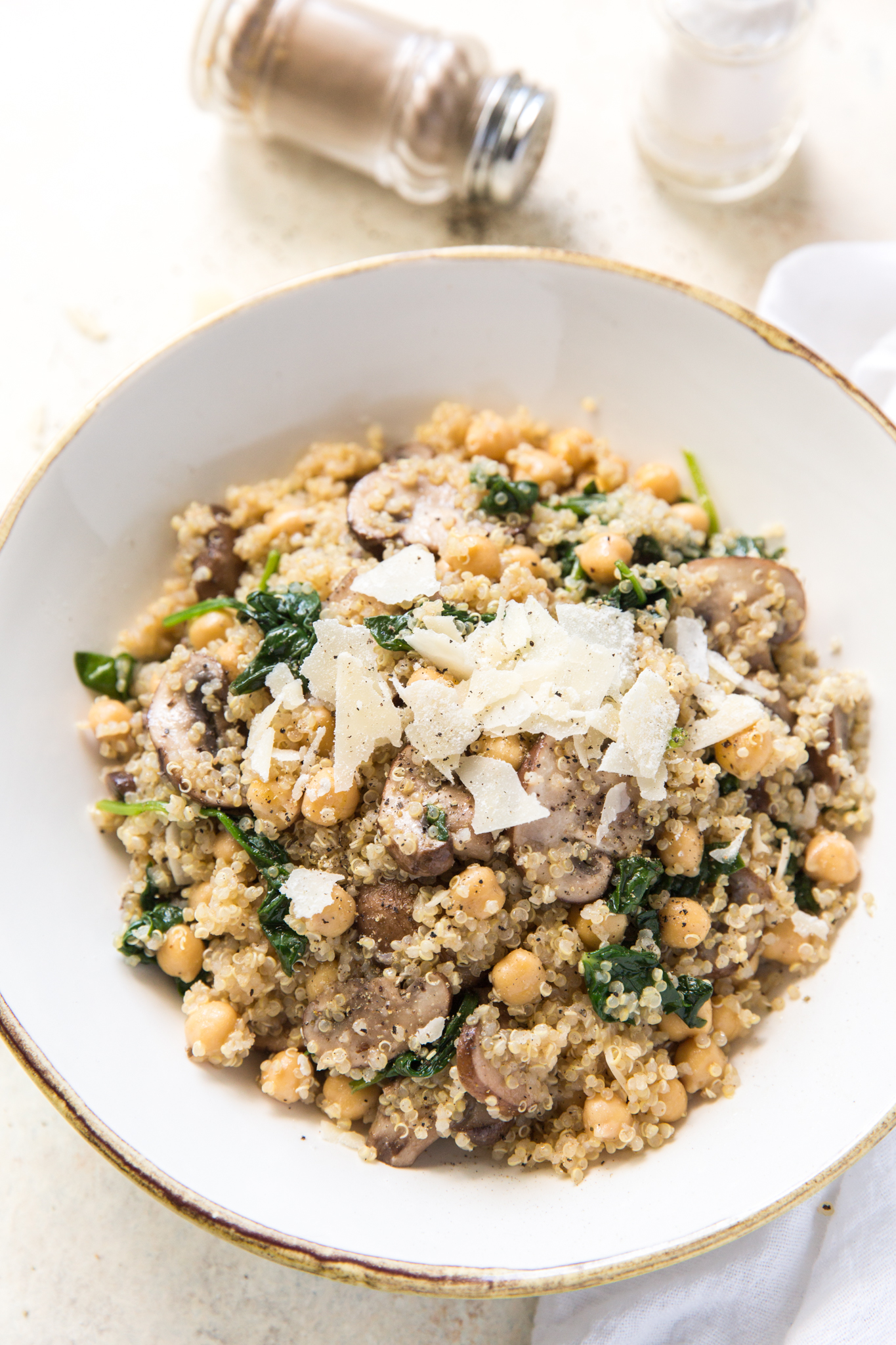 overhead view of a quinoa veggie bowl topped with shaved parmesan 