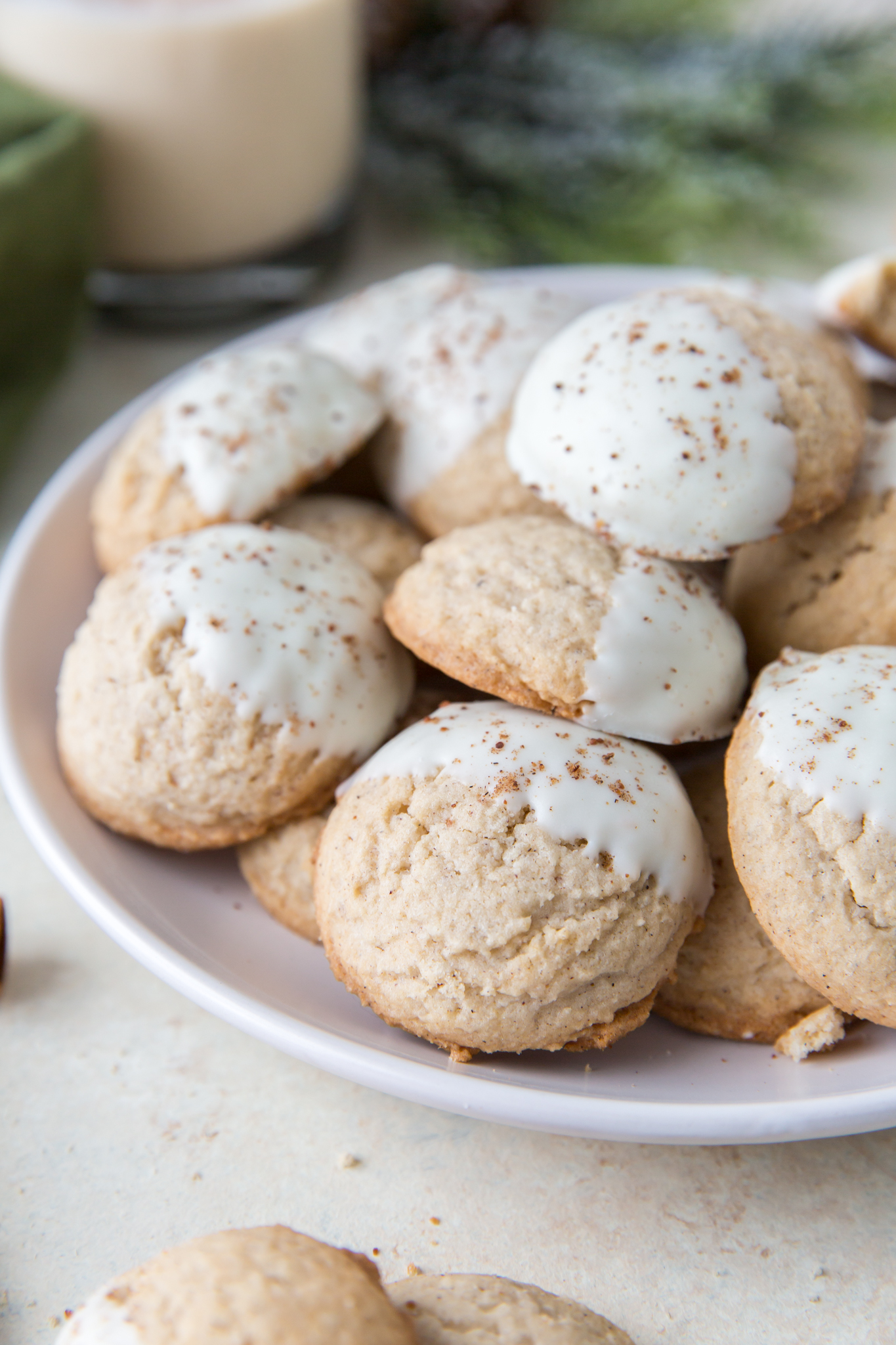 eggnog sugar cookies piled on a white plate 