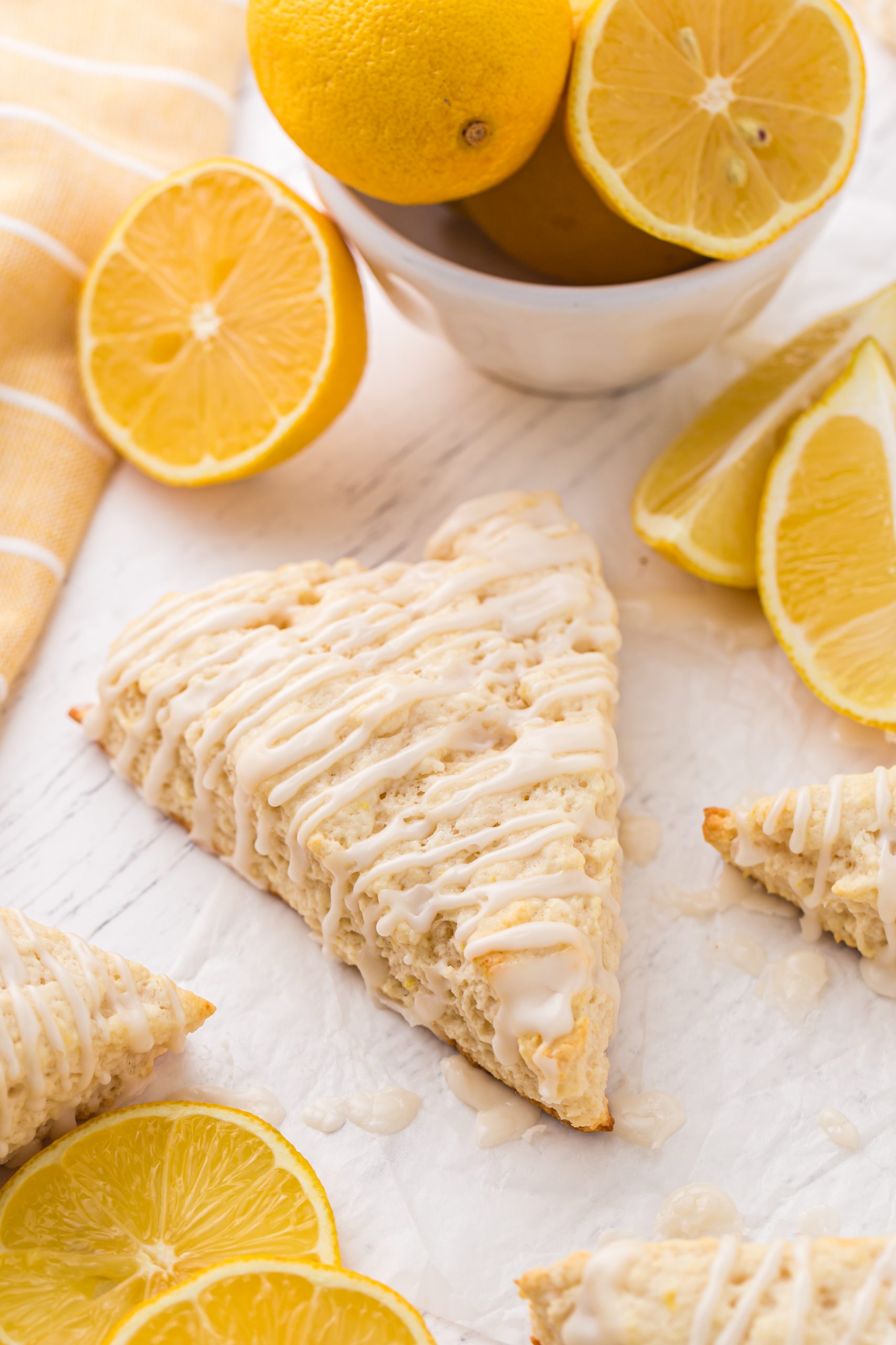 lemon scones on counter, surrounded by lemon halves and wedges