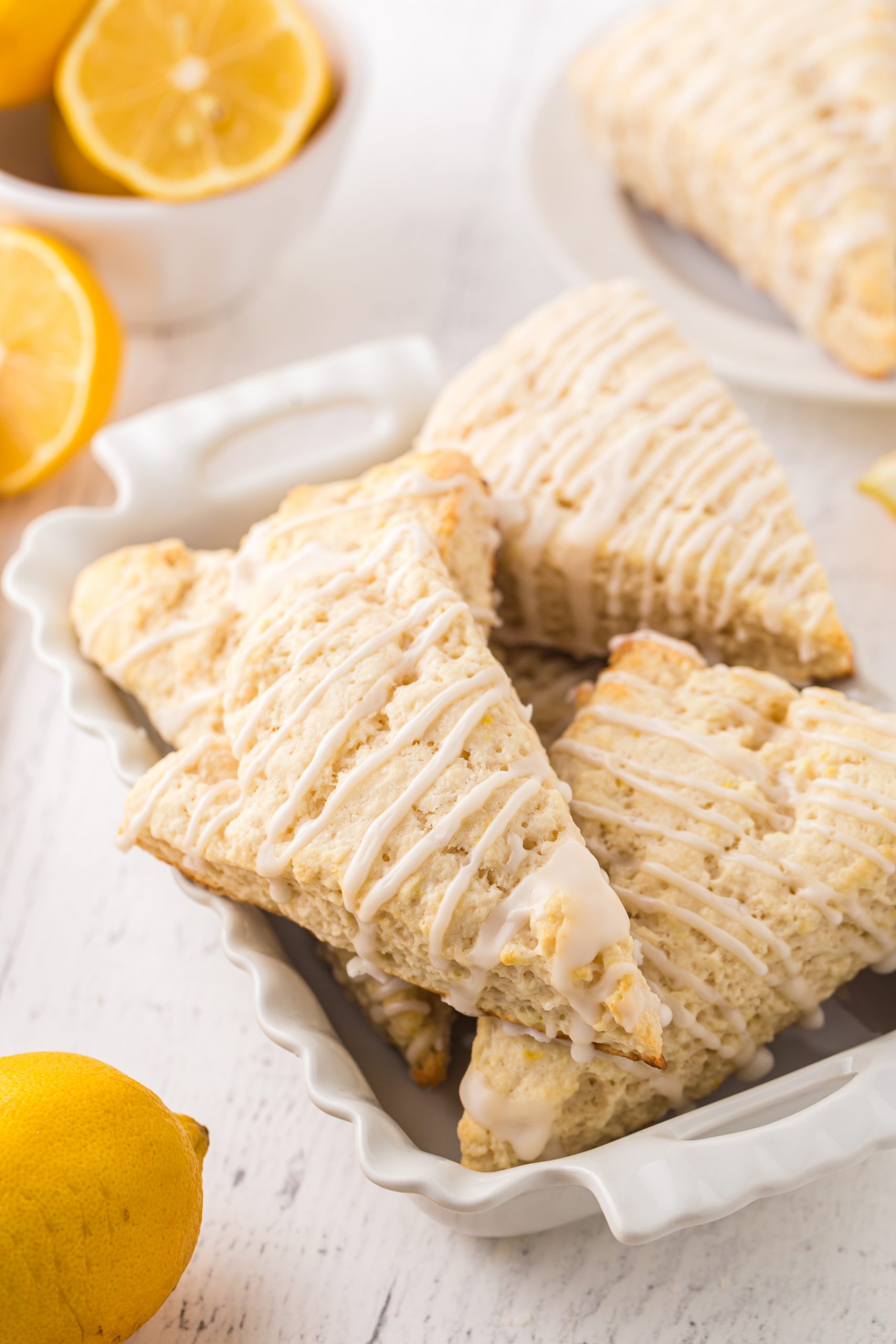 A white serving dish piled high with lemon scones 