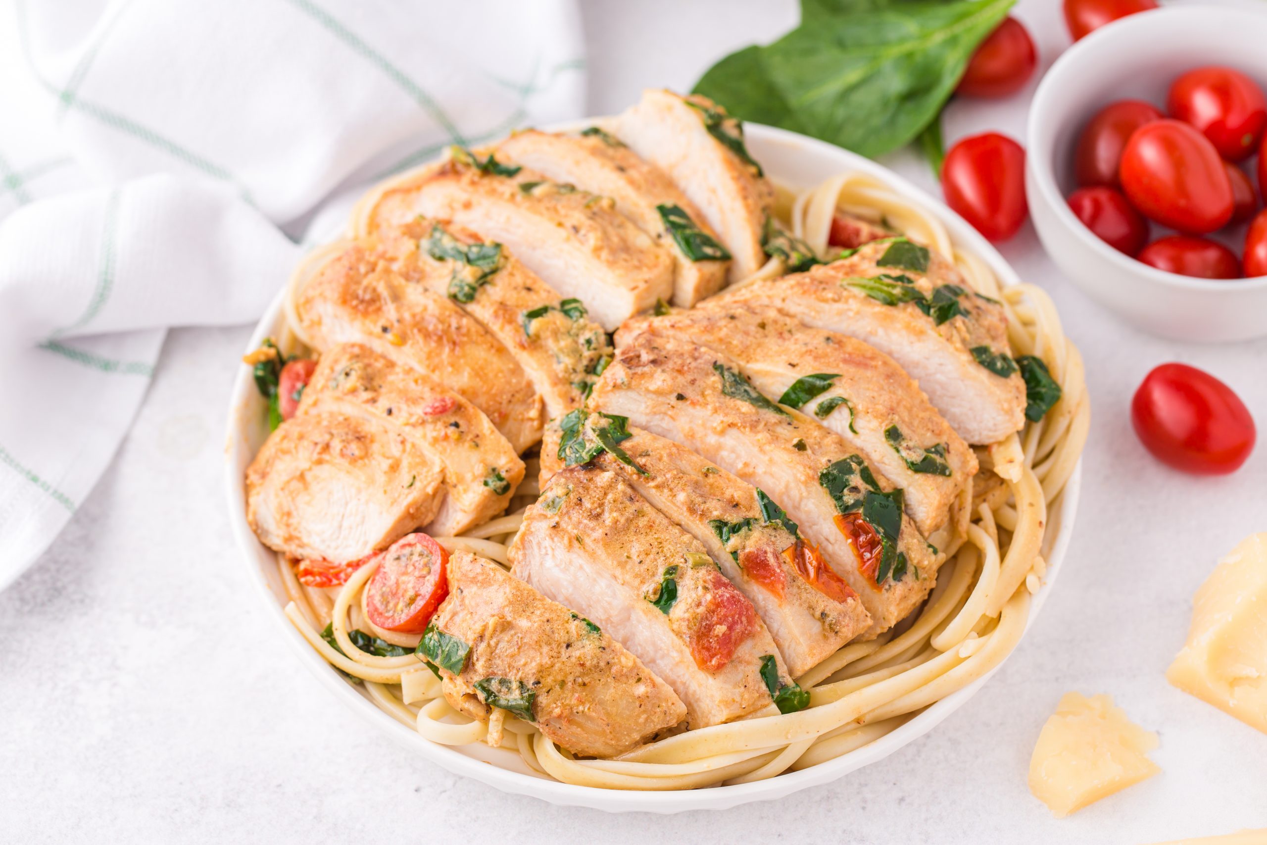 chicken over pasta on white plate