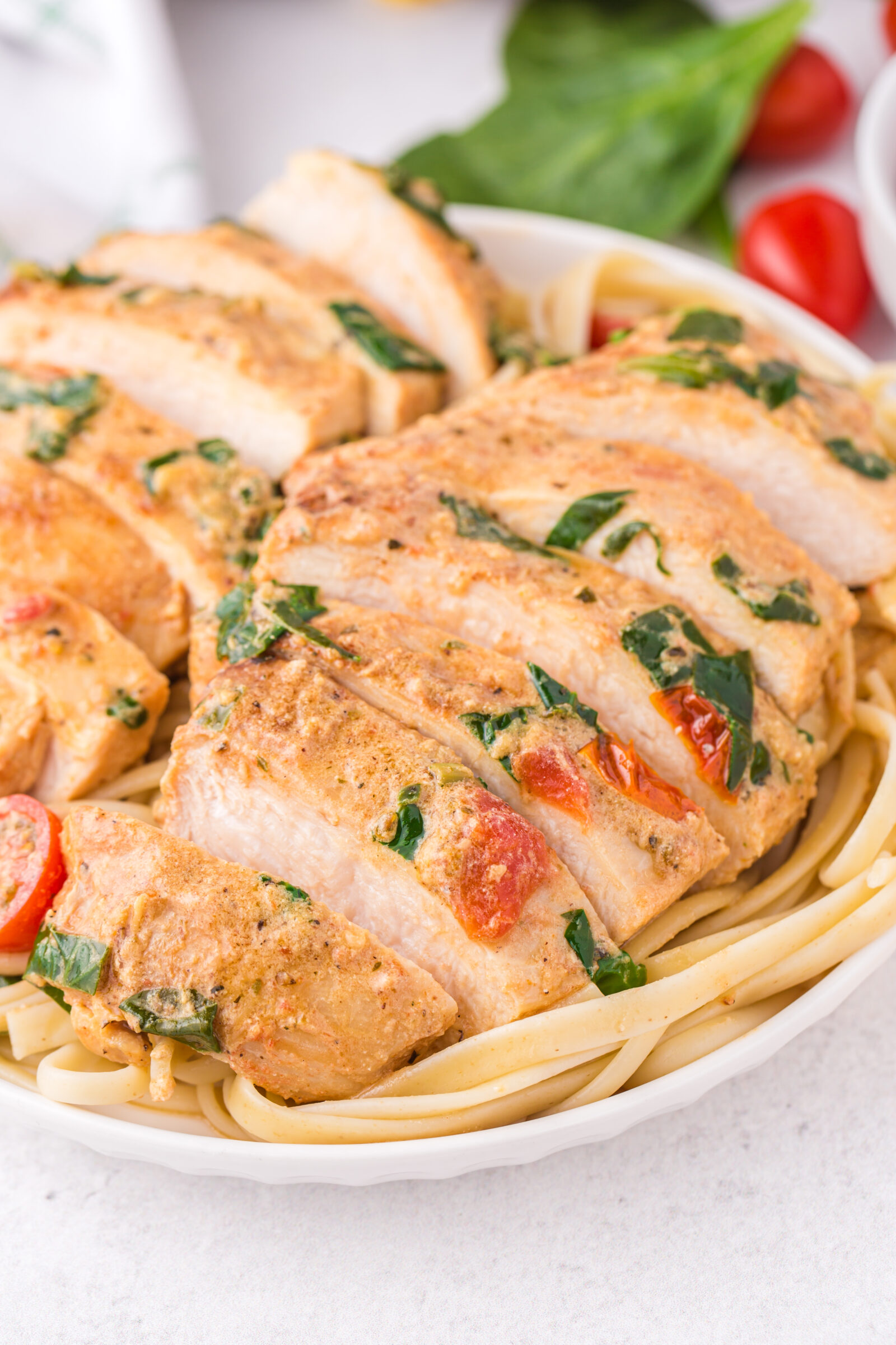 chicken over pasta on a white plate