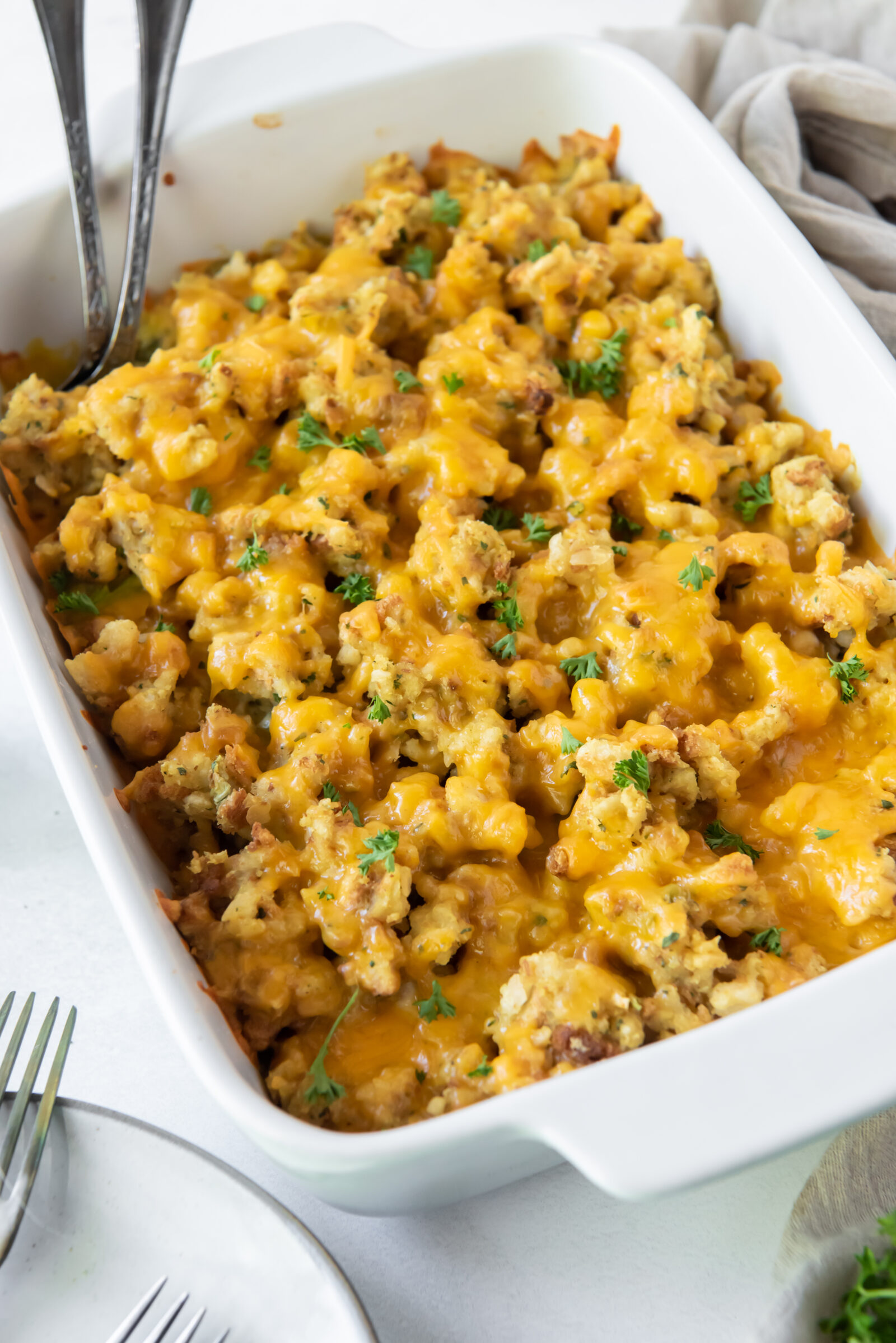 Cheesy chicken and broccoli casserole in a white baking dish. 