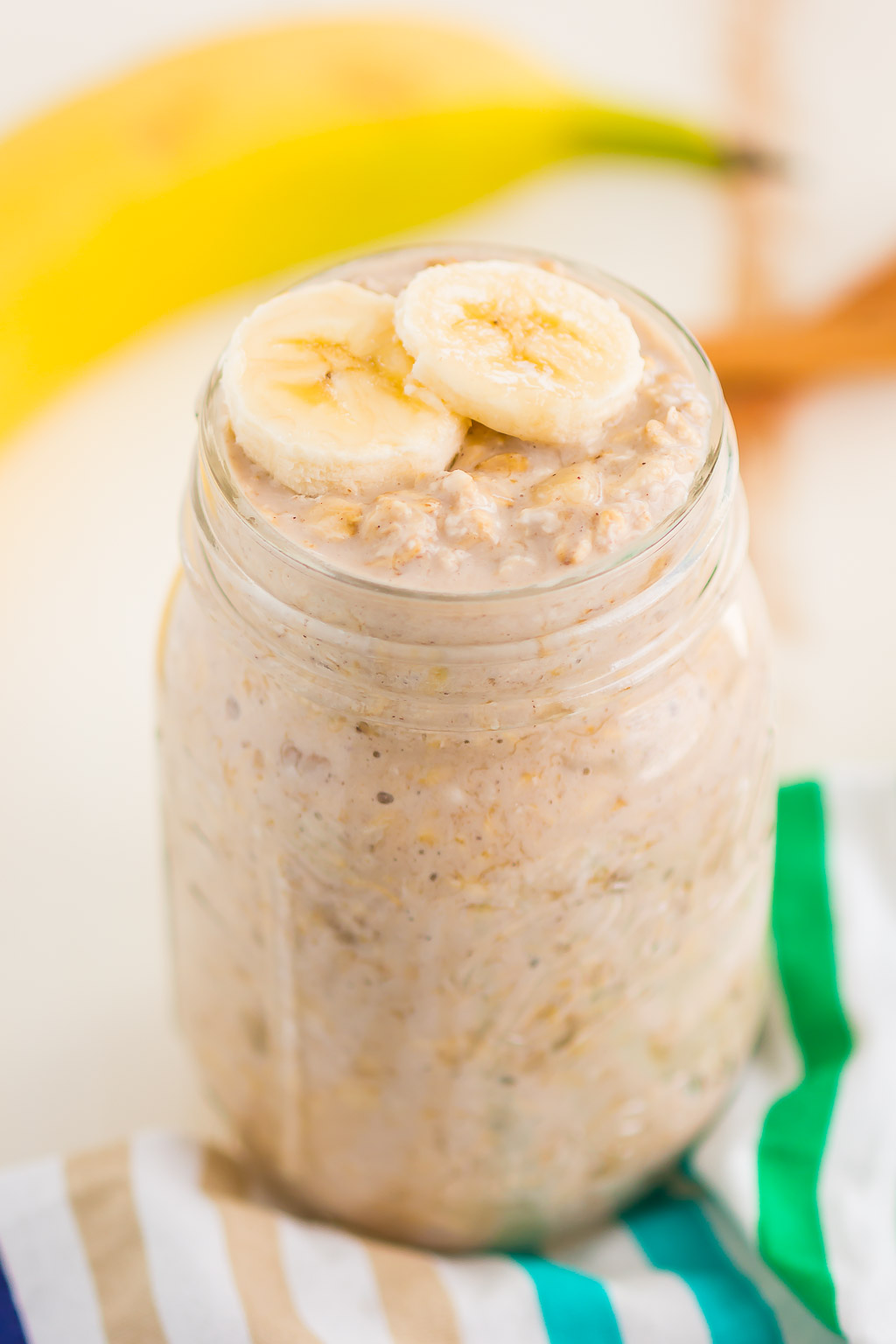 A mason jar of banana overnight oats topped with two banana slices. 