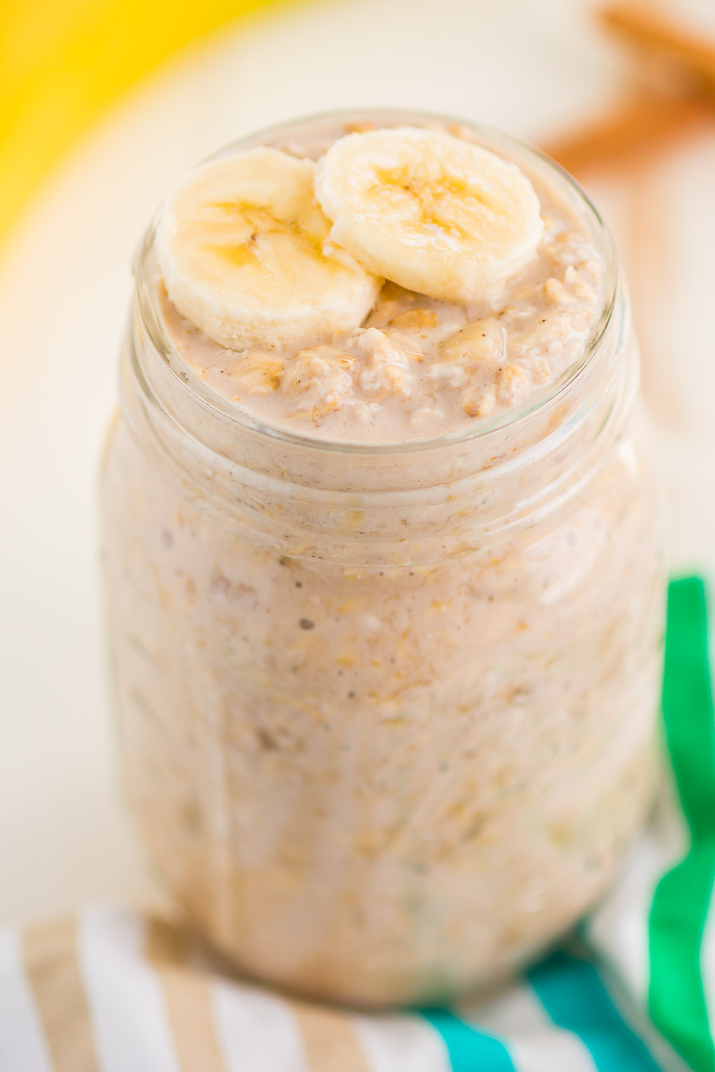 A mason jar of banana overnight oats topped with two banana slices. 