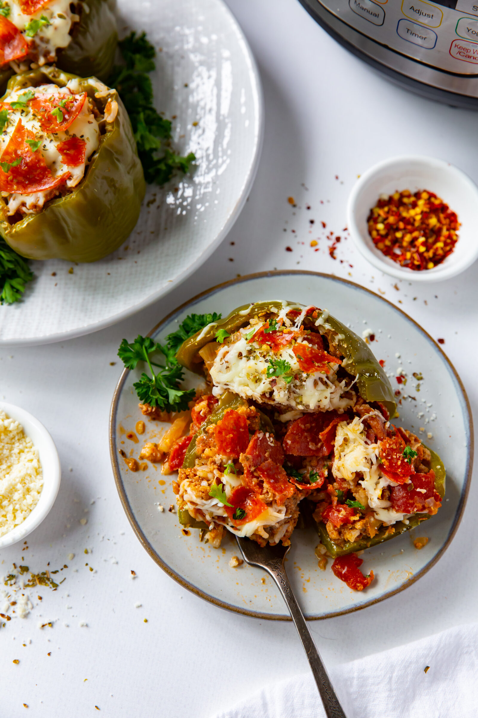 An Instant Pot stuffed pepper on a plate that's partially eaten, seen from above. 