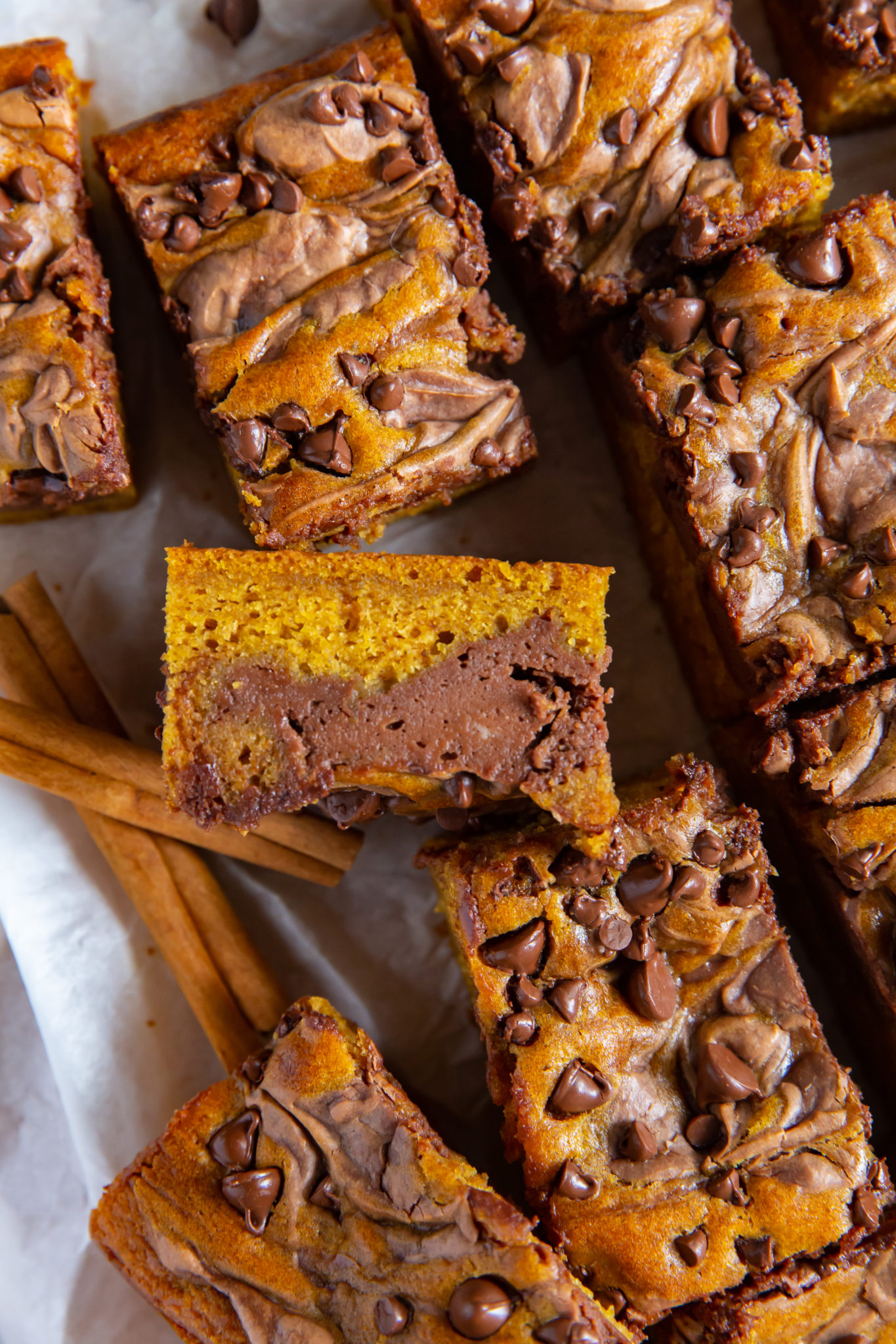 Overhead view of sliced pumpkin chocolate bars on a wooden board.