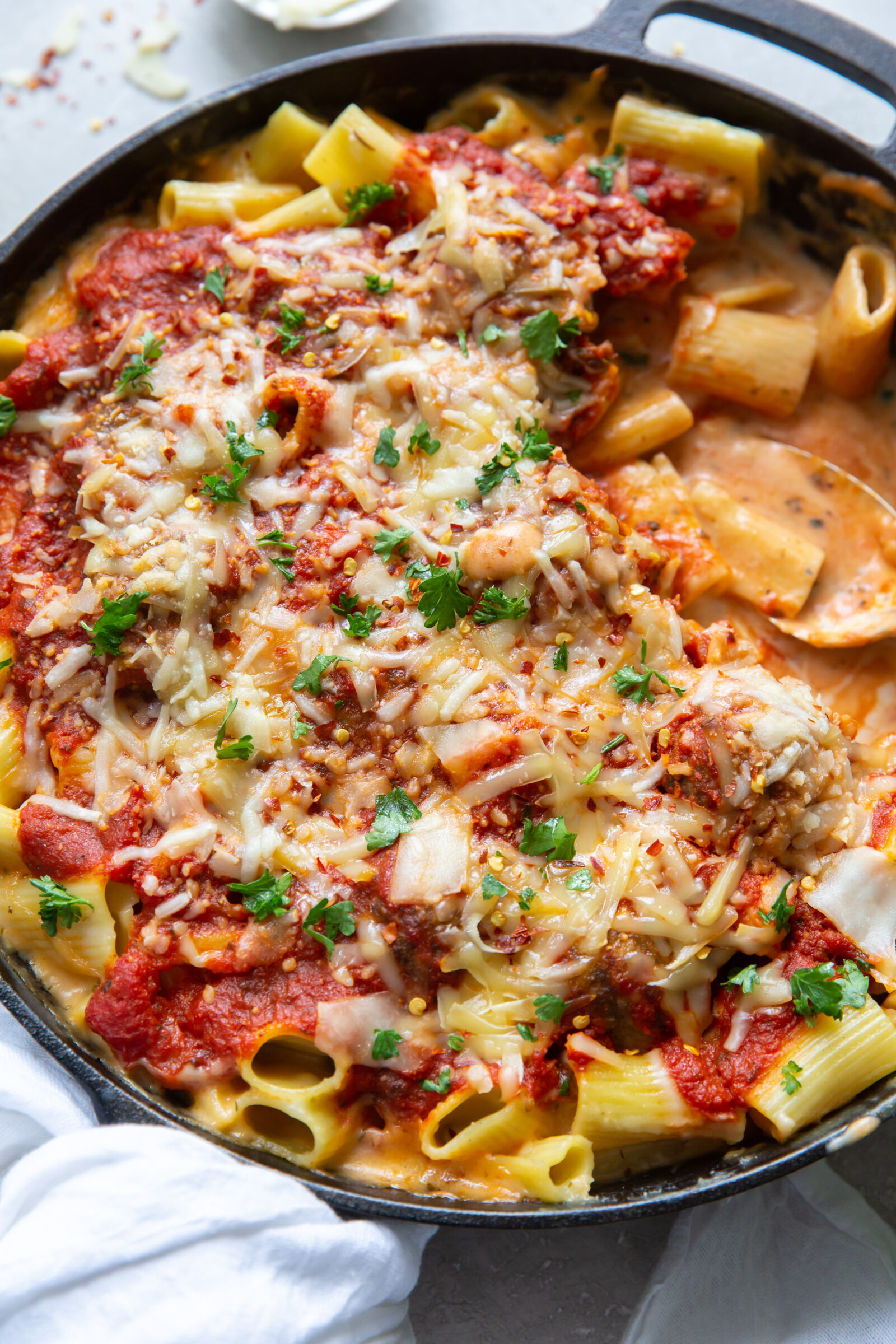 Overhead view of a cast iron skillet full of meatball mac and cheese. 