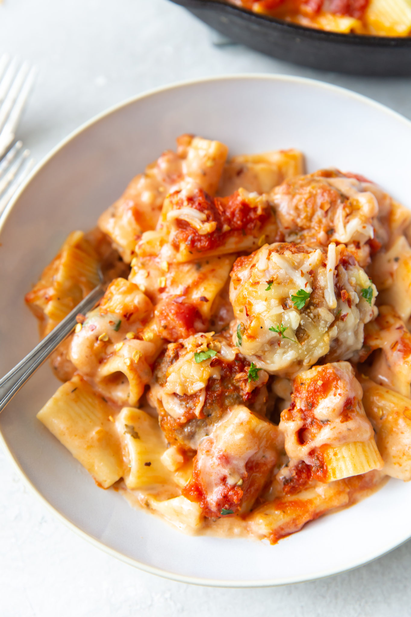 Overhead view of meatball mac and cheese garnished with grated Parmesan.