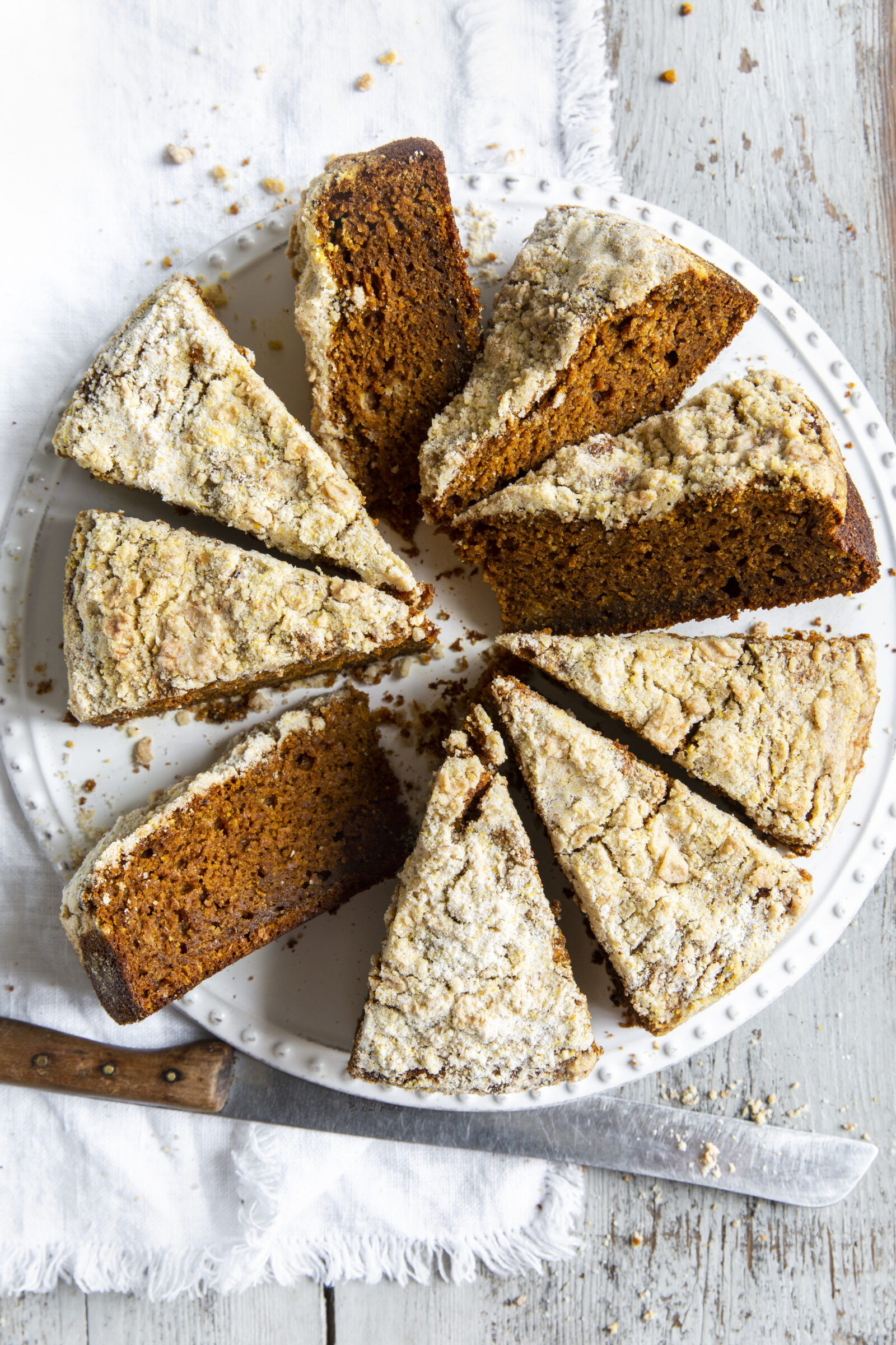 Overhead view of pumpkin streusel coffee cake slices on a white platter. 