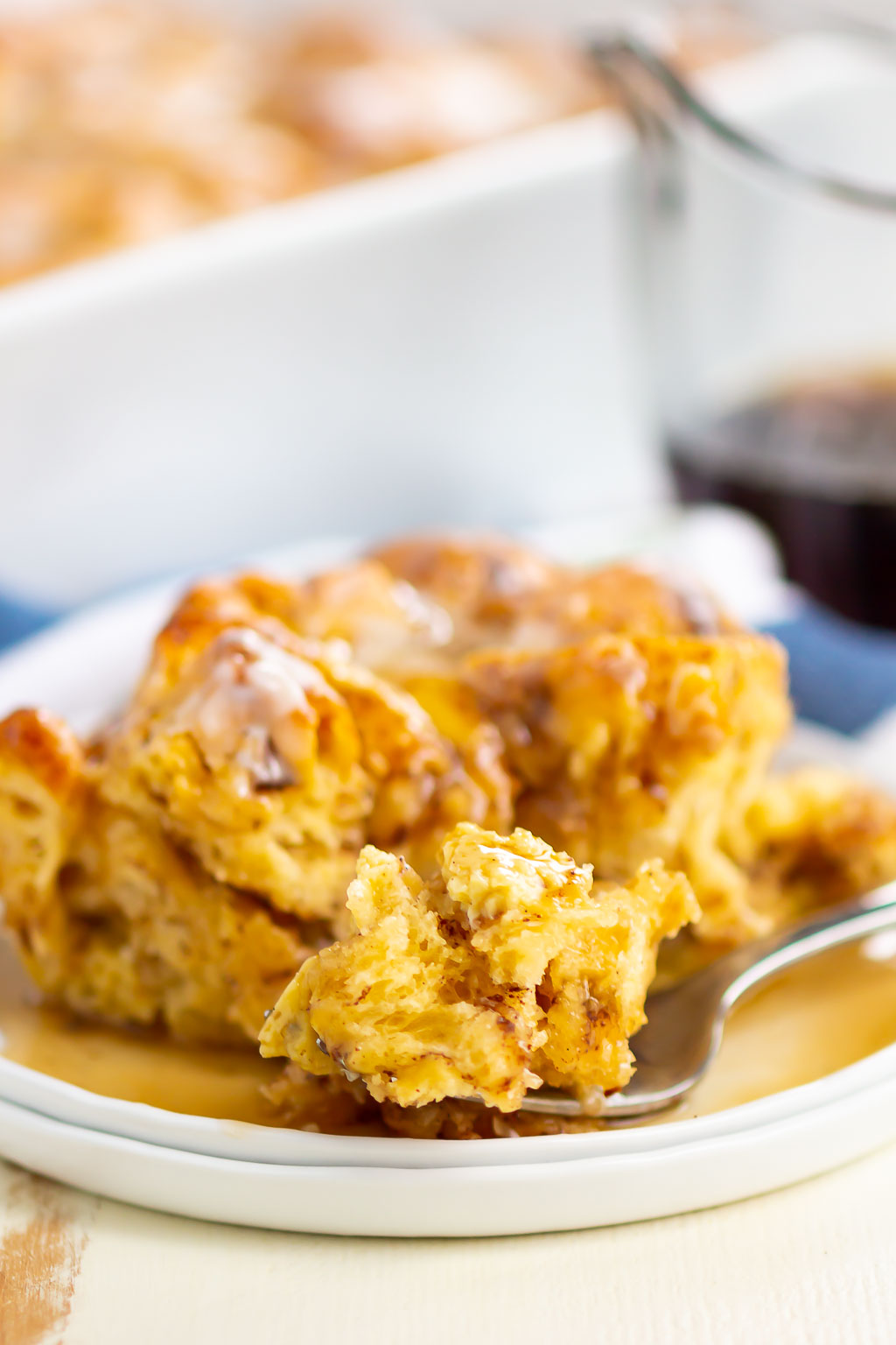 french toast on a white plate with a fork and syrup