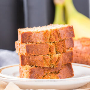 banana bread slices stacked on a white plate