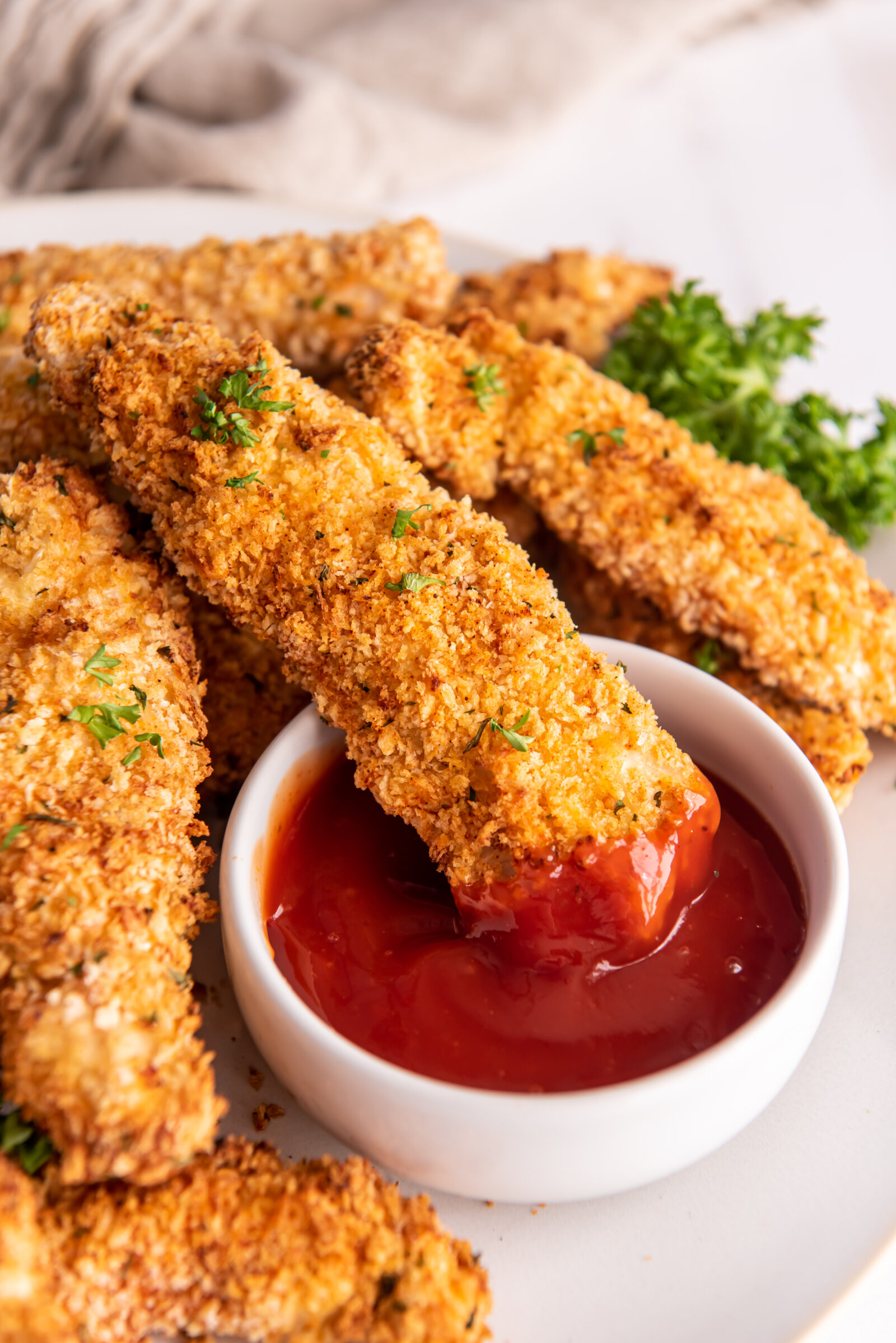 chicken strips on a white plate with sauce