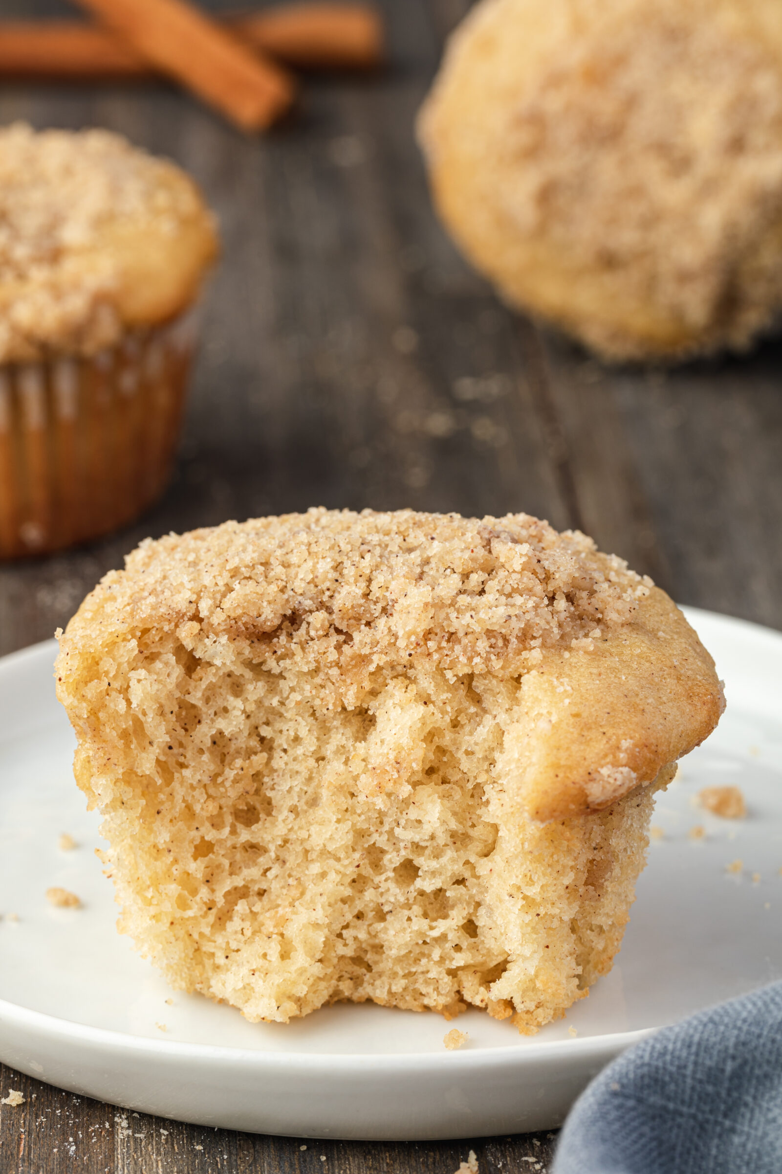 A pancake mix muffin with a bite missing on a white plate. 