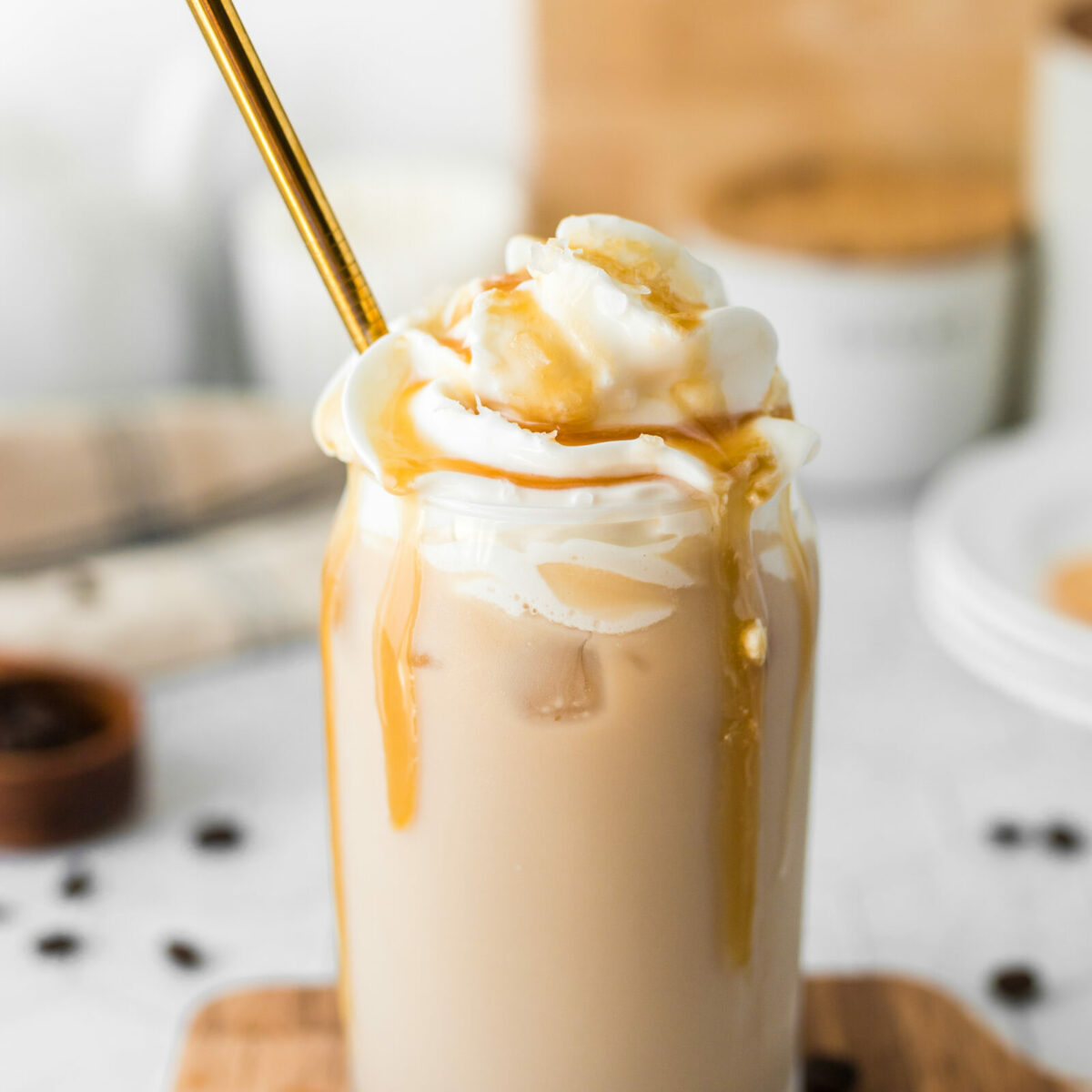 An iced caramel latte topped with whipped cream and drizzled with caramel sauce.