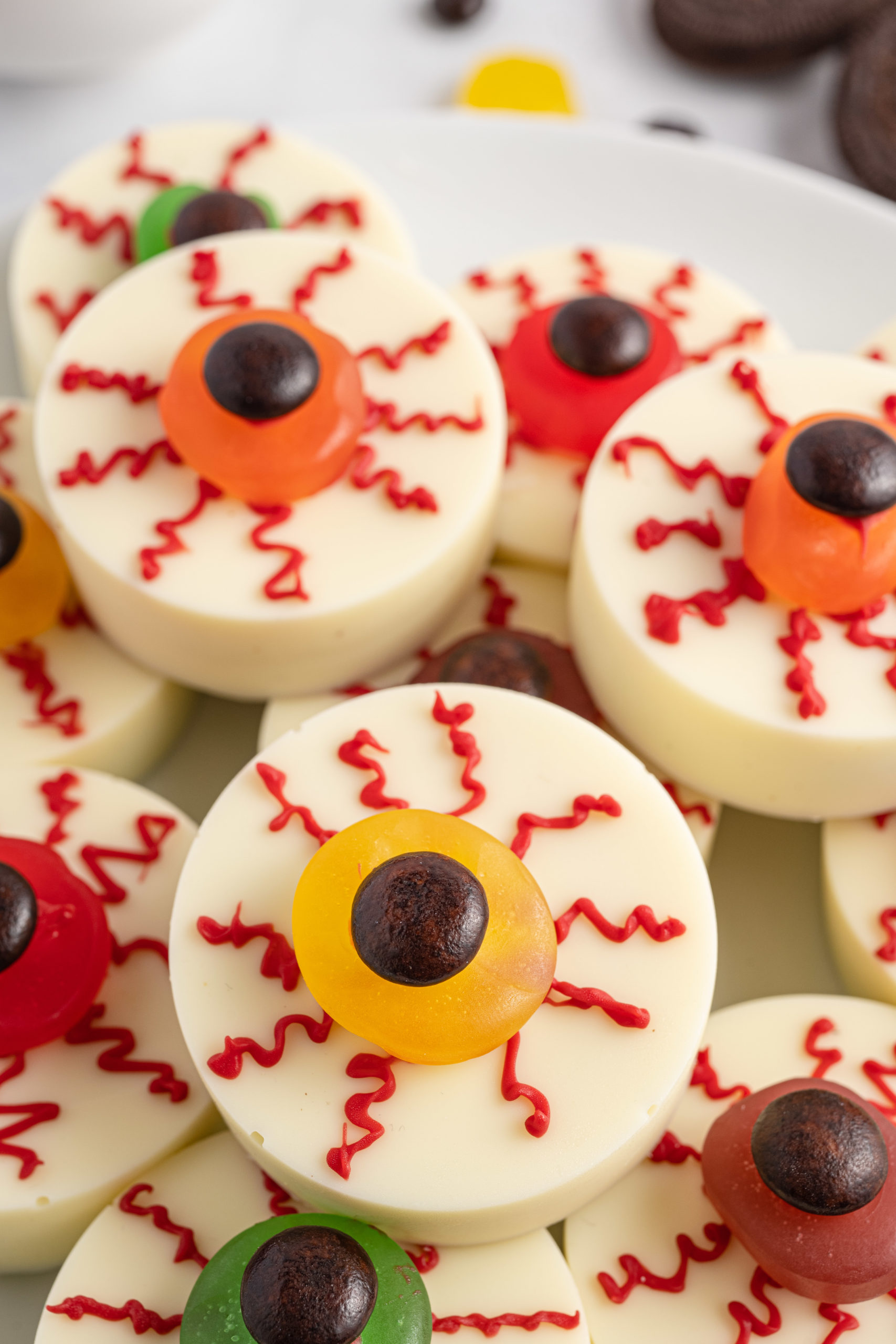 A plate of white chocolate covered Oreos decorated to look like eyeballs. 