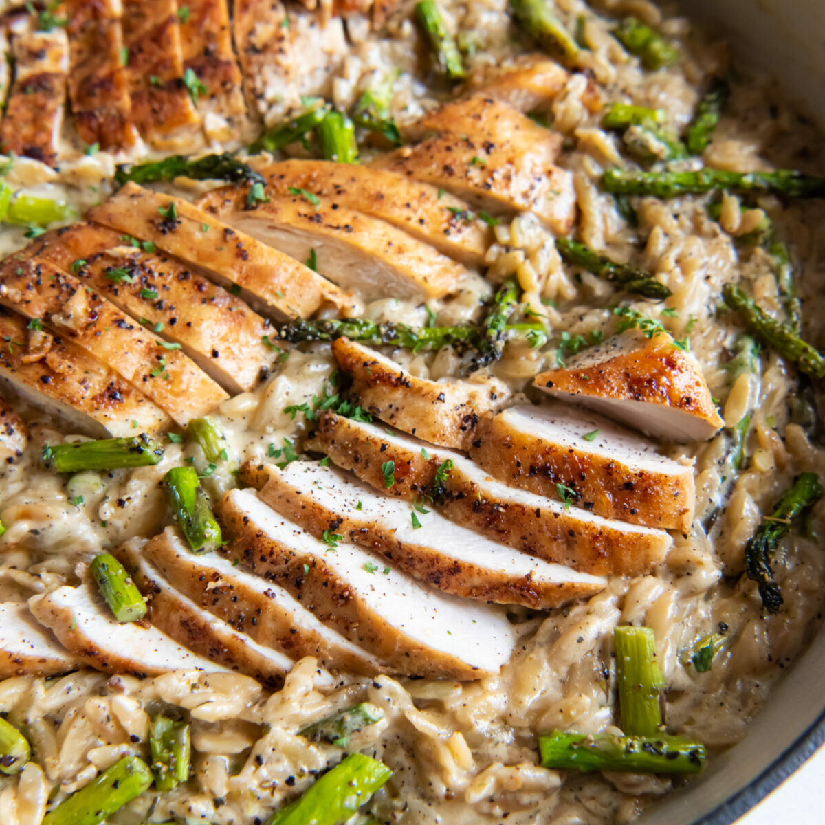 Asparagus orzo with chicken in a Dutch oven.