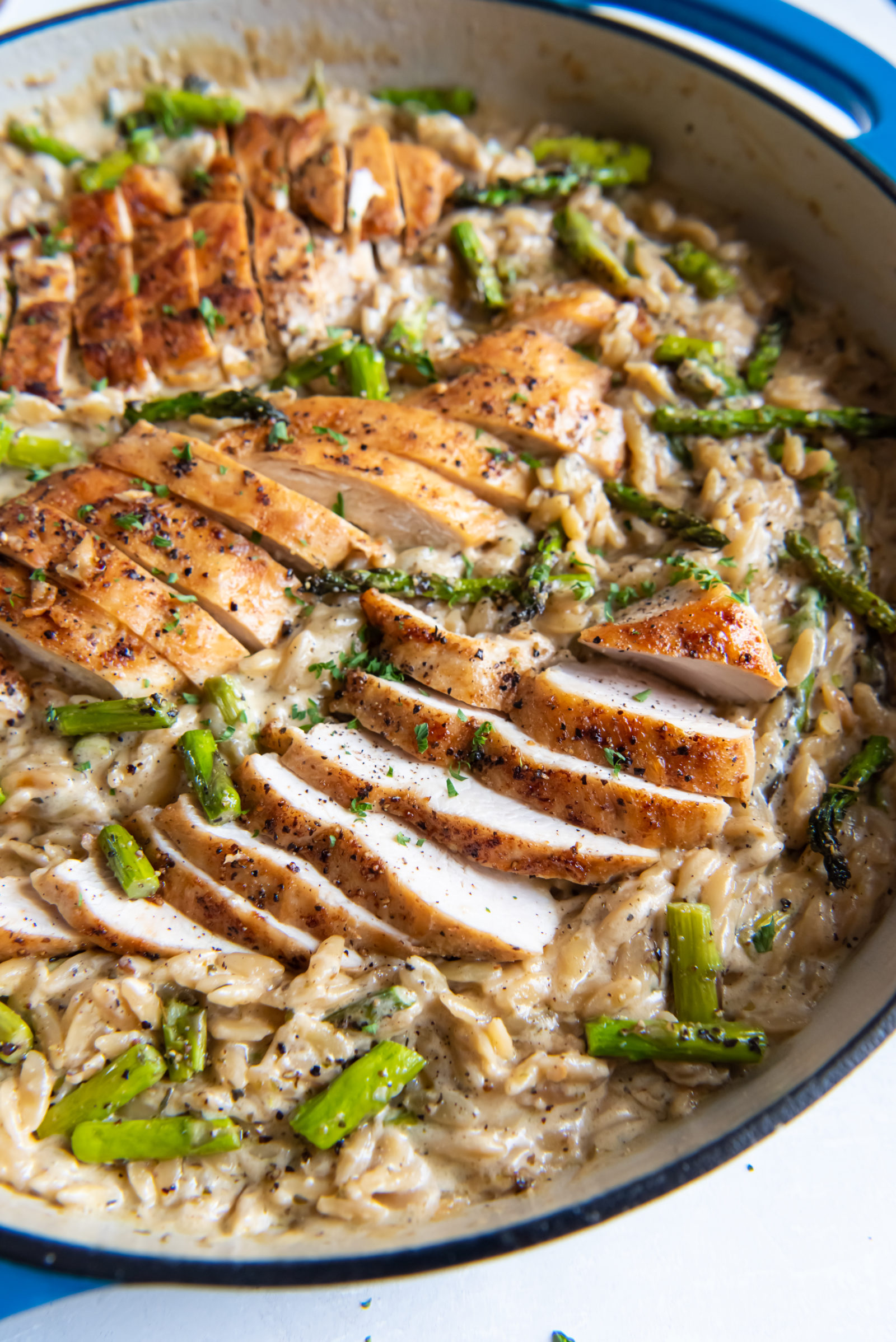 Asparagus orzo with chicken in a Dutch oven. 