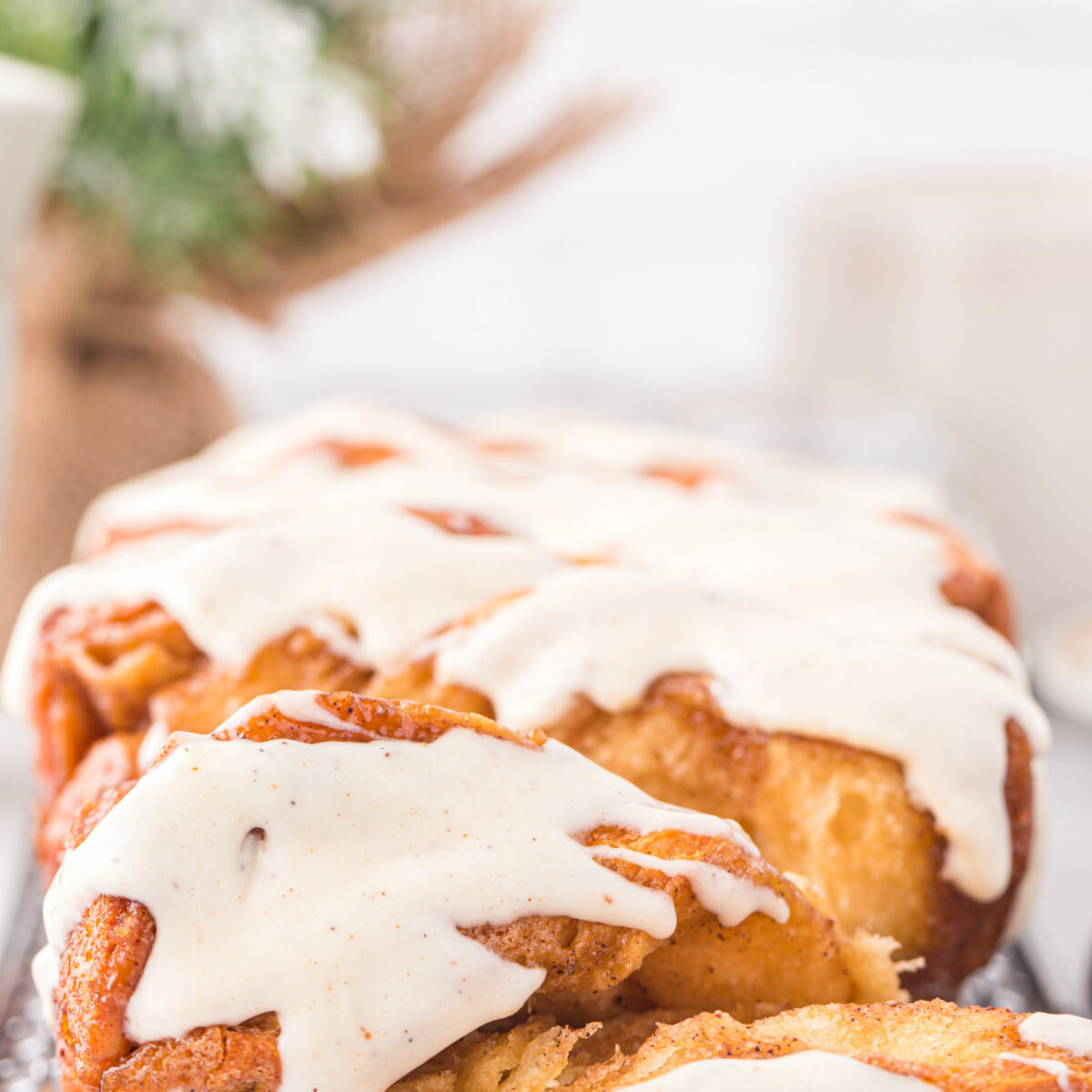 A loaf of glazed eggnog pull-apart bread on a wire rack.