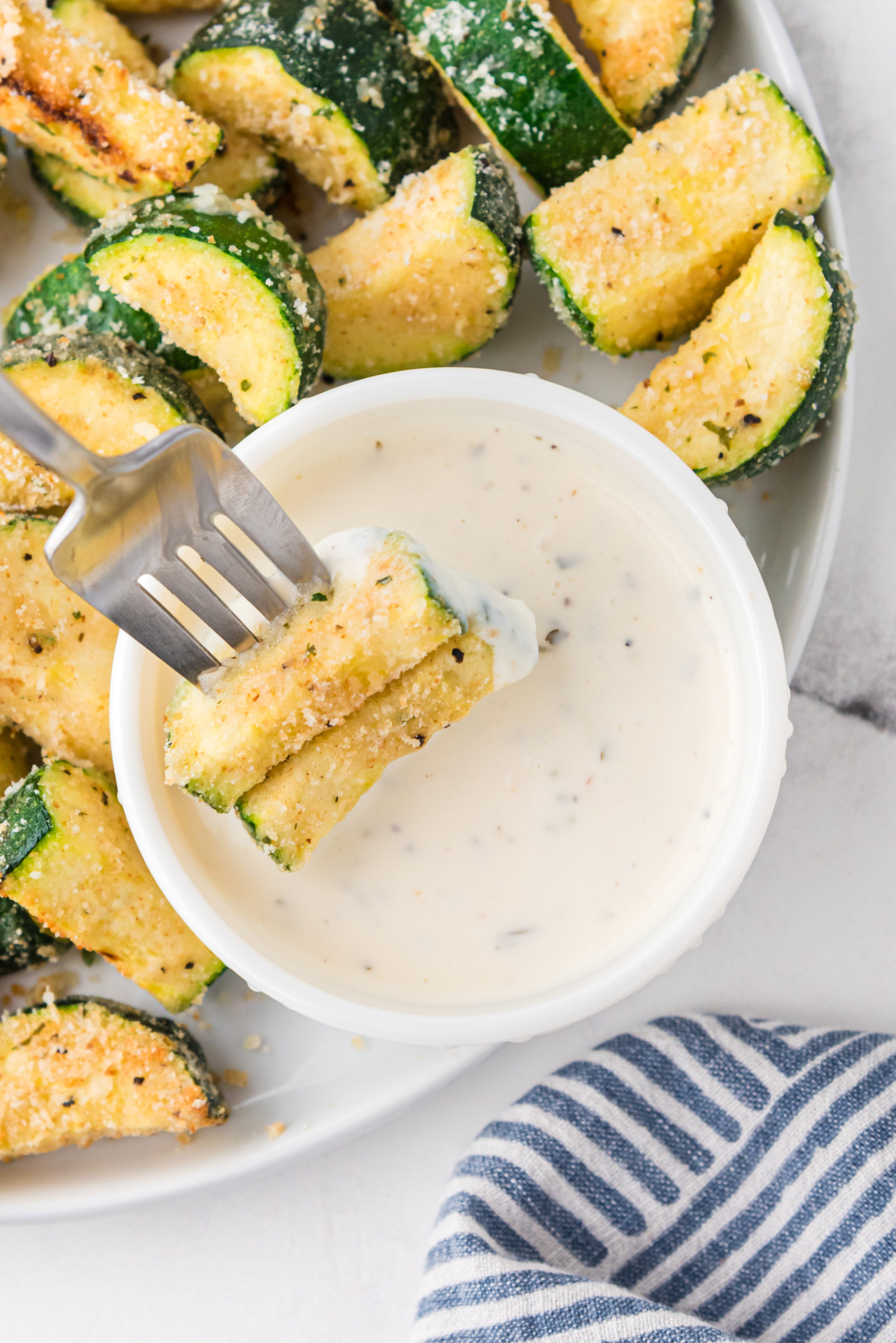 zucchini on a white plate with dip