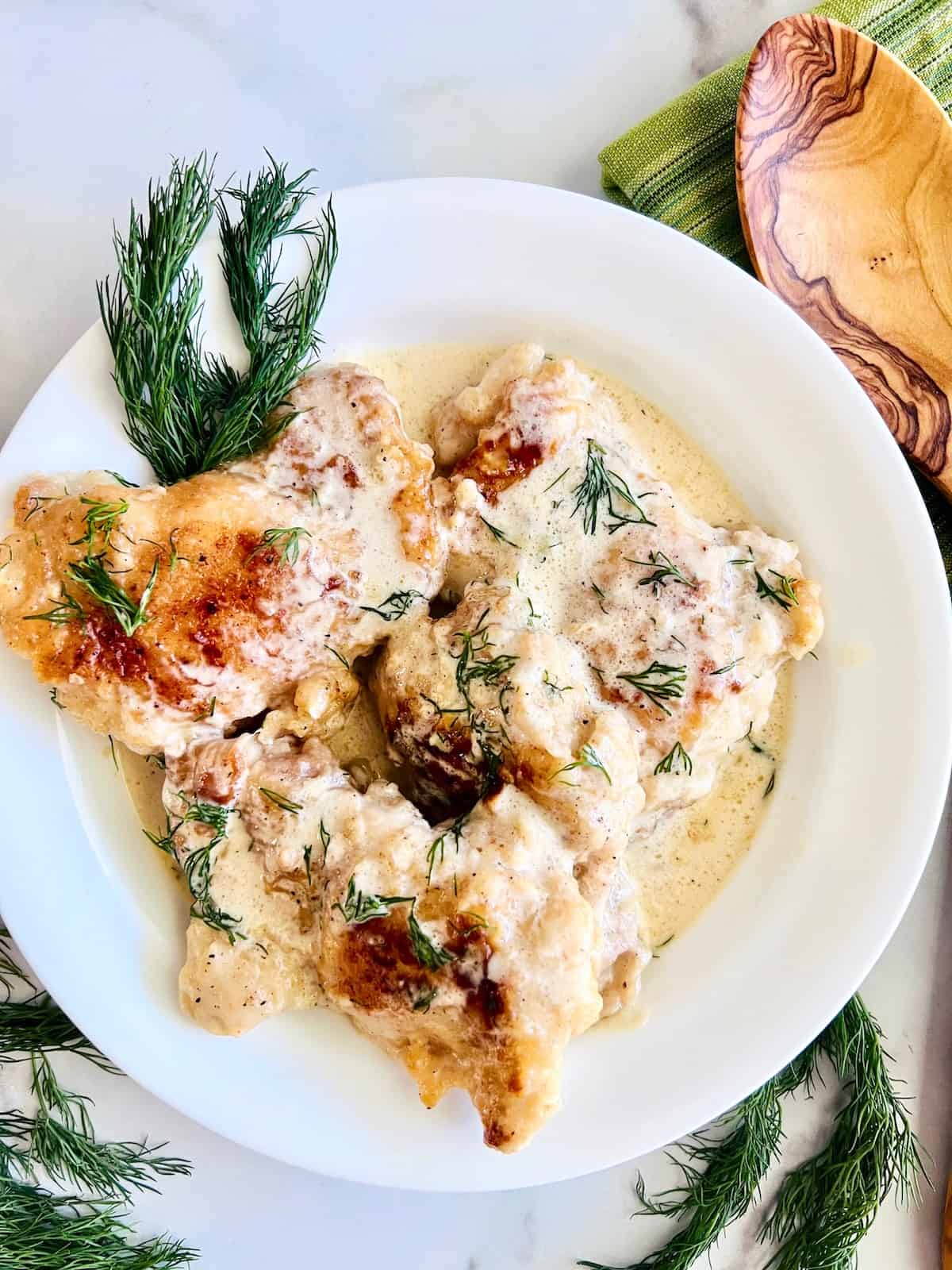 https://www.pumpkinnspice.com/wp-content/uploads/2022/12/Creamy-Lemon-Dill-Butter-Chicken-Plated-with-fresh-dill-on-top-and-as-a-garnish.jpeg