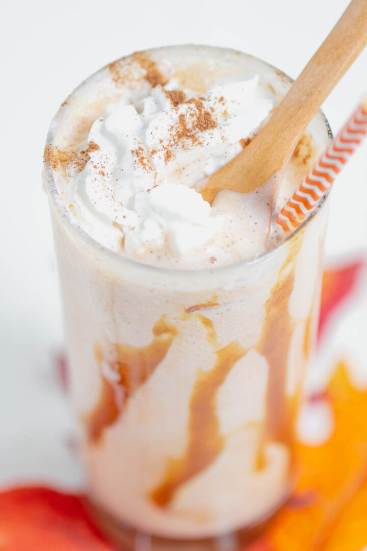 pumpkin shake in a clear glass with a wooden spoon